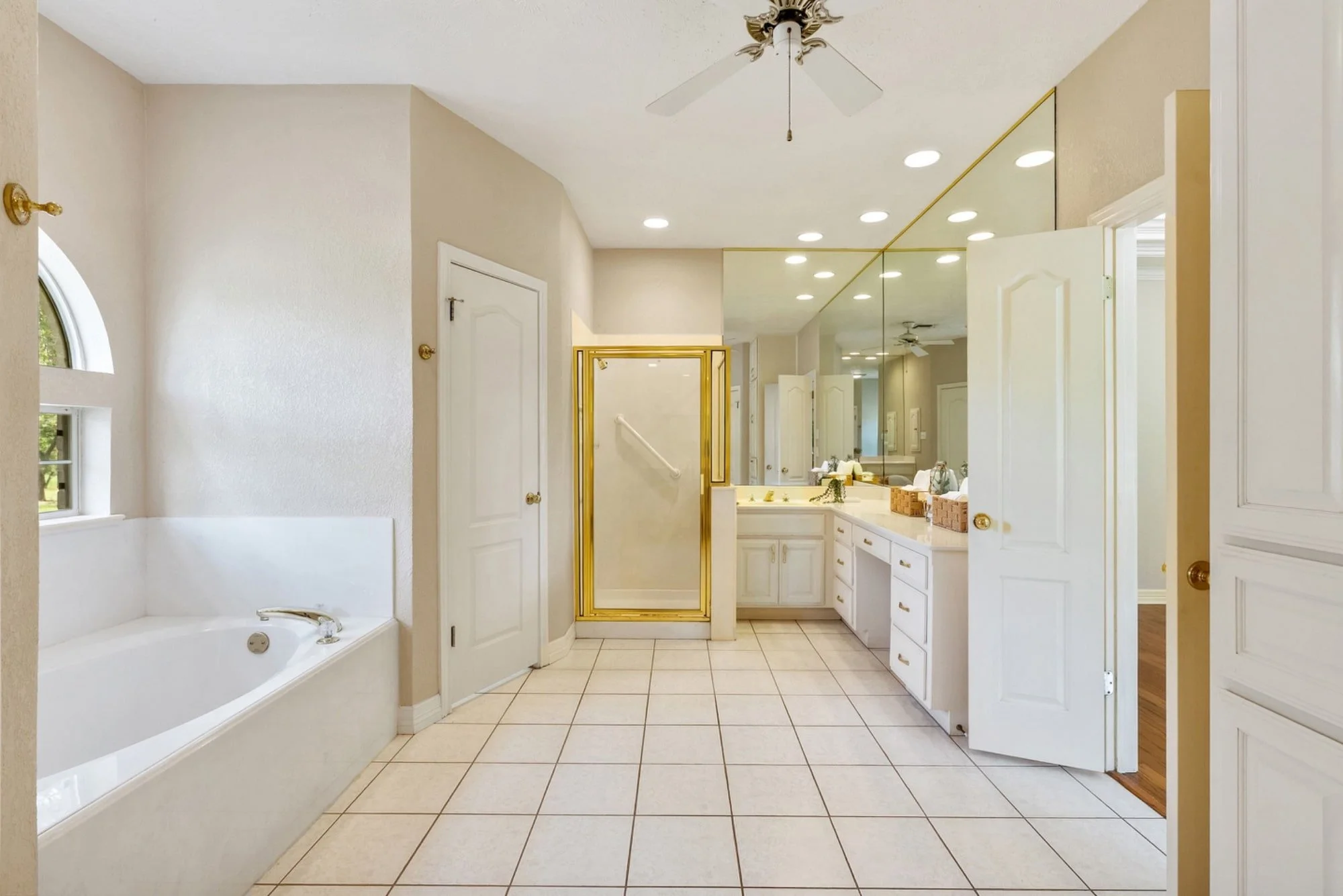 Primary bathroom with a soaking tub, walk-in shower, and dual vanity with oversized mirrors.