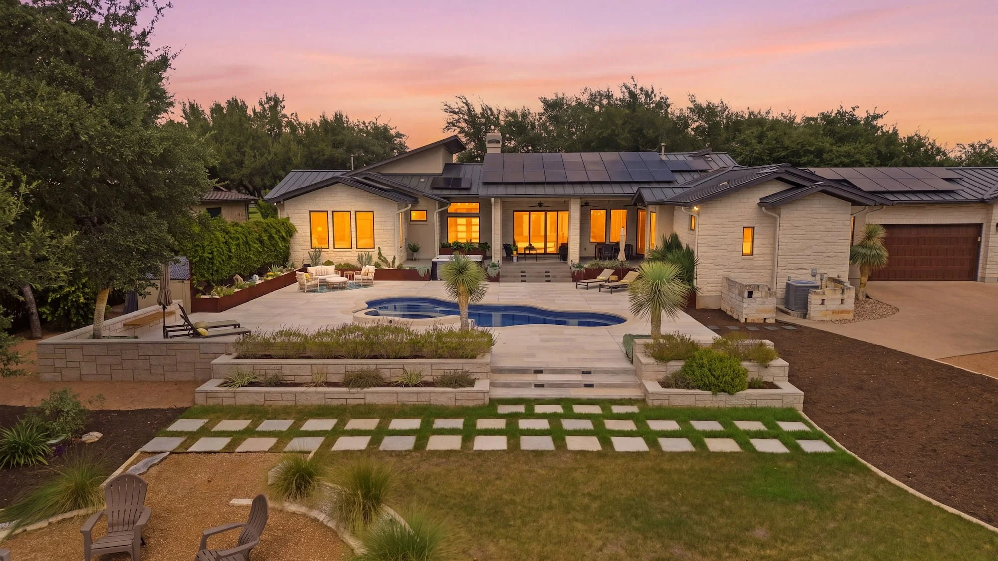 Aerial dusk view of a staged backyard with a freeform pool and patio seating.