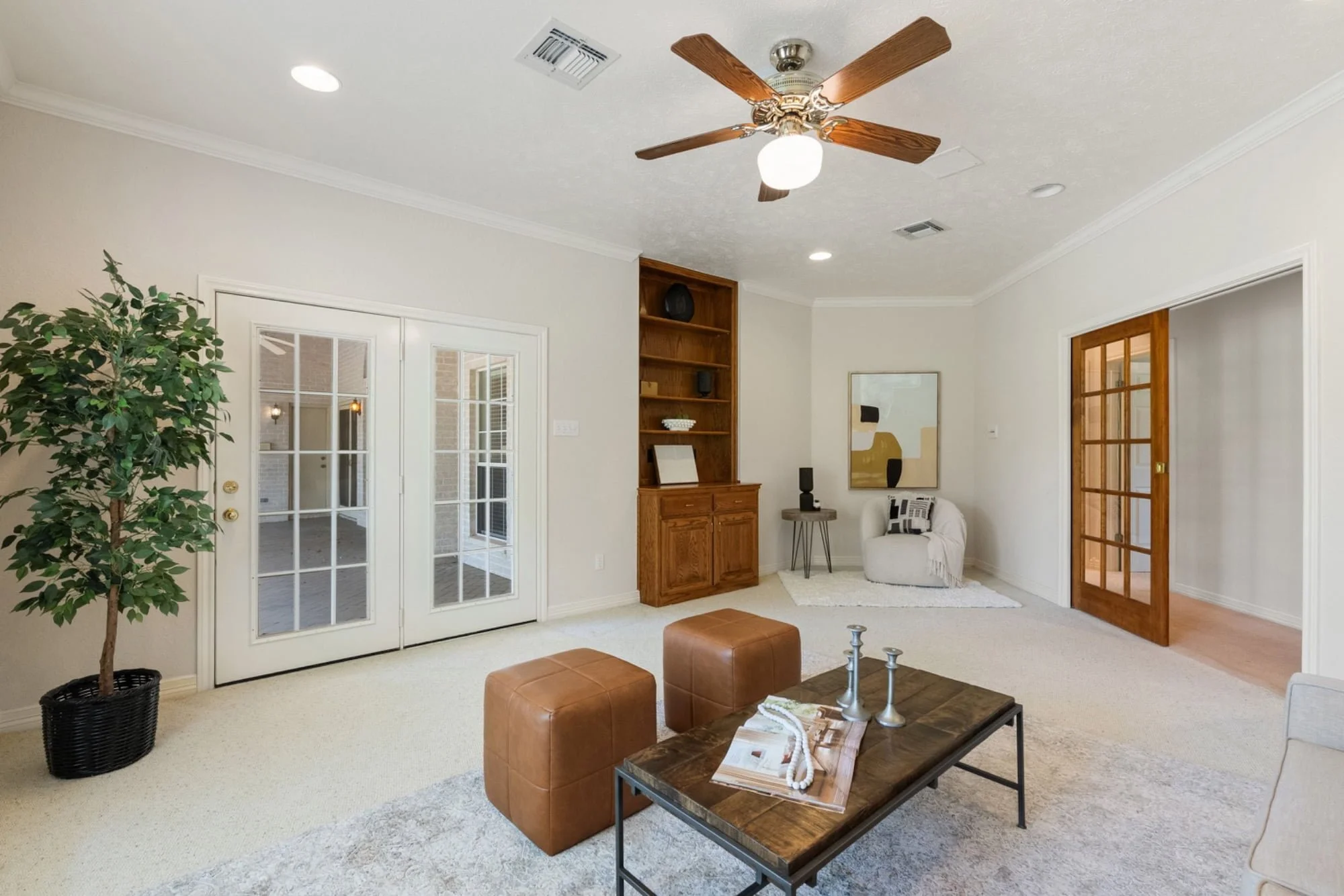Additional living area with built-in shelving, patio access, and space for seating or a home office.