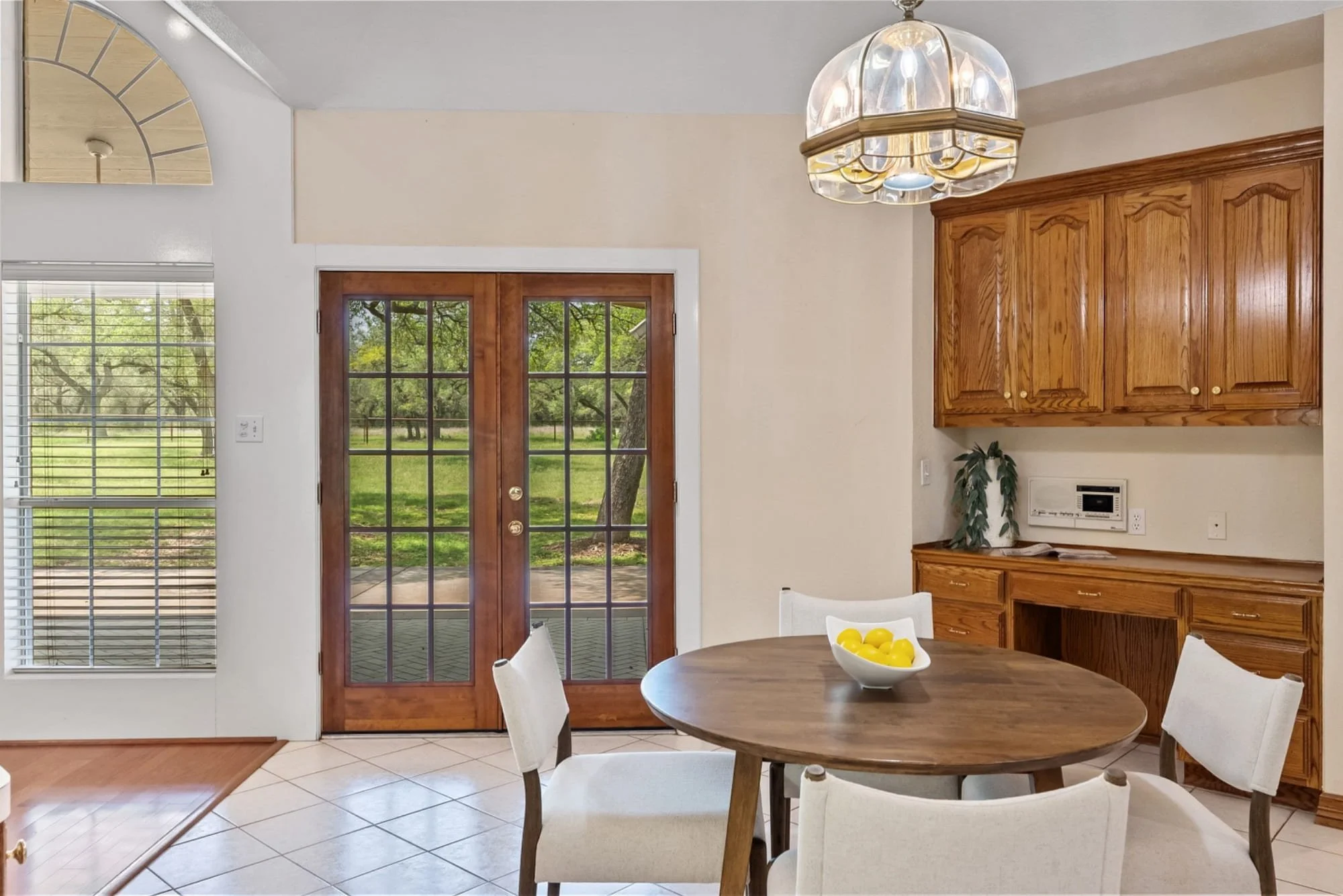 Breakfast area with a round dining table, built-in cabinetry, and backyard view.