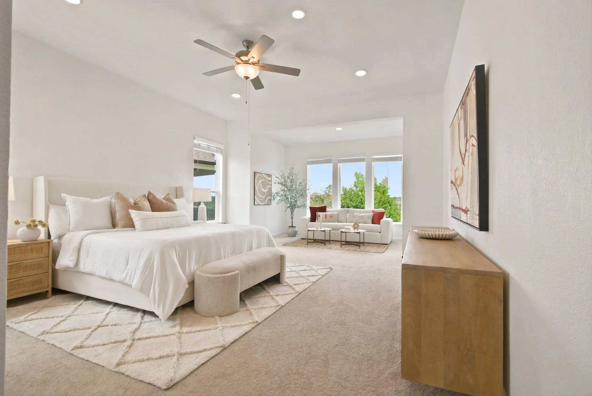 The primary bedroom pairs a plush bed with a light-filled sitting nook.