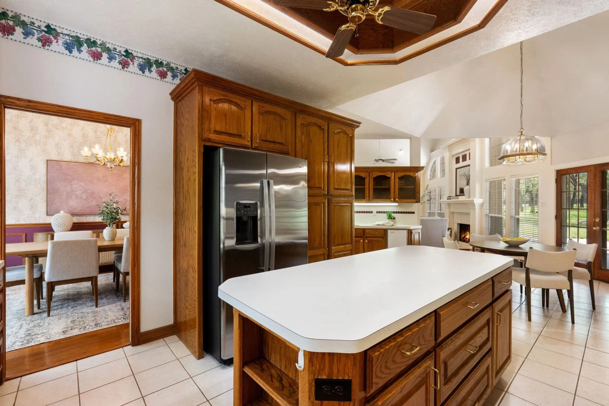 Kitchen with a center island, wood cabinetry, and views into the dining and living areas.