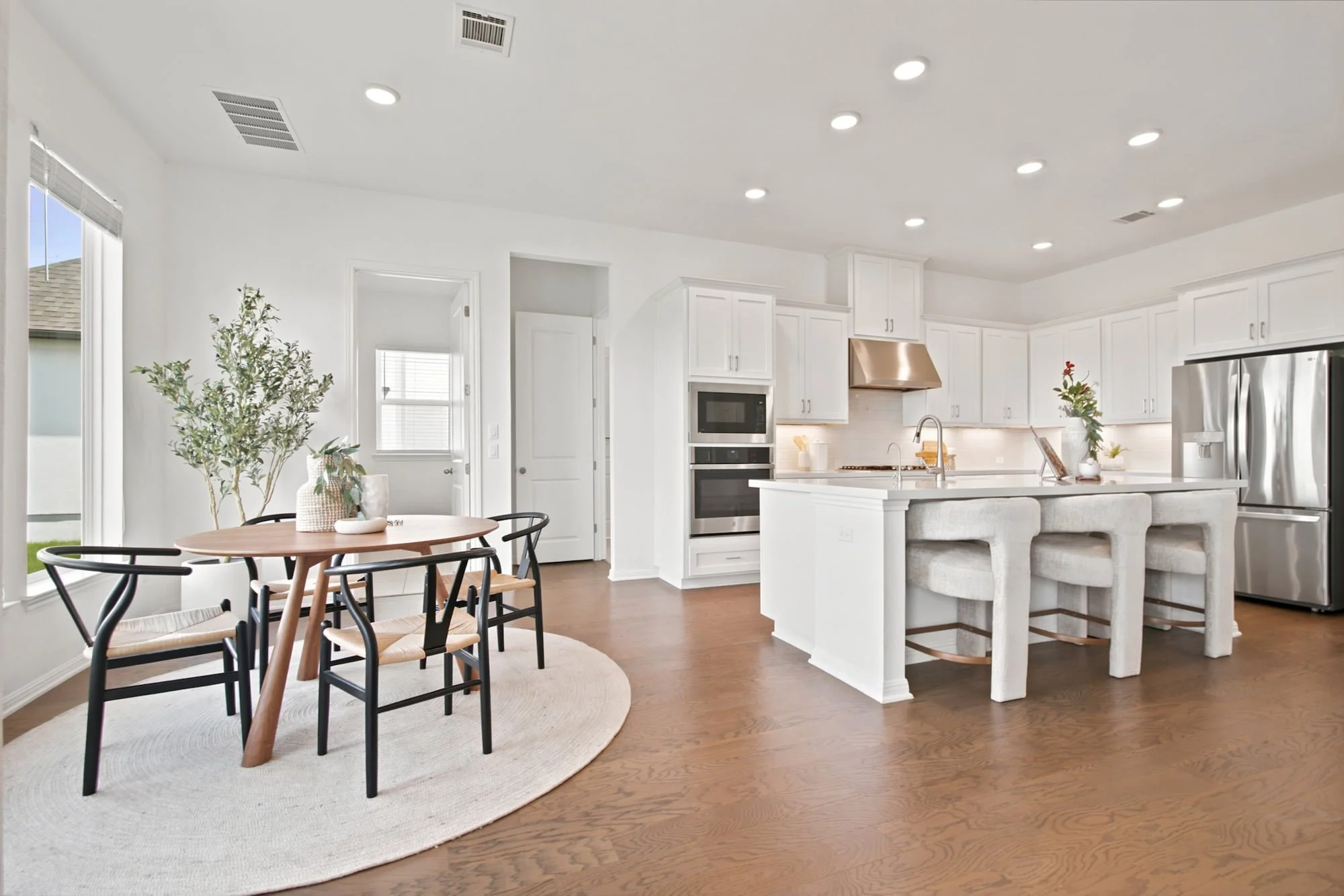 Stainless appliances line the kitchen, with a wood breakfast table set just steps away.