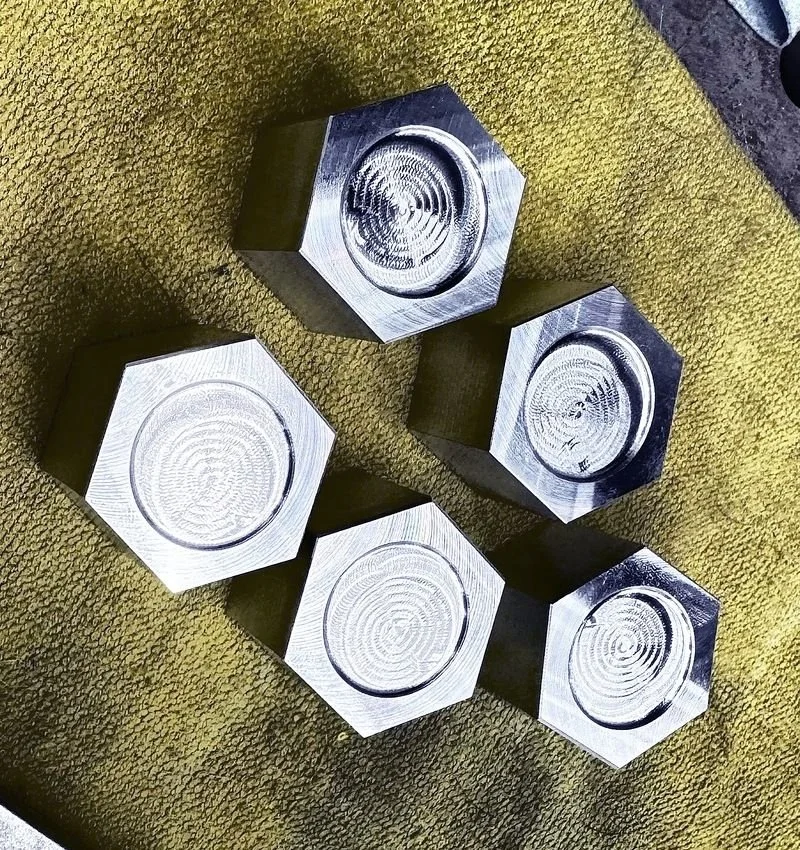Raw machined billet shock tower caps showing the unfinished aluminum face