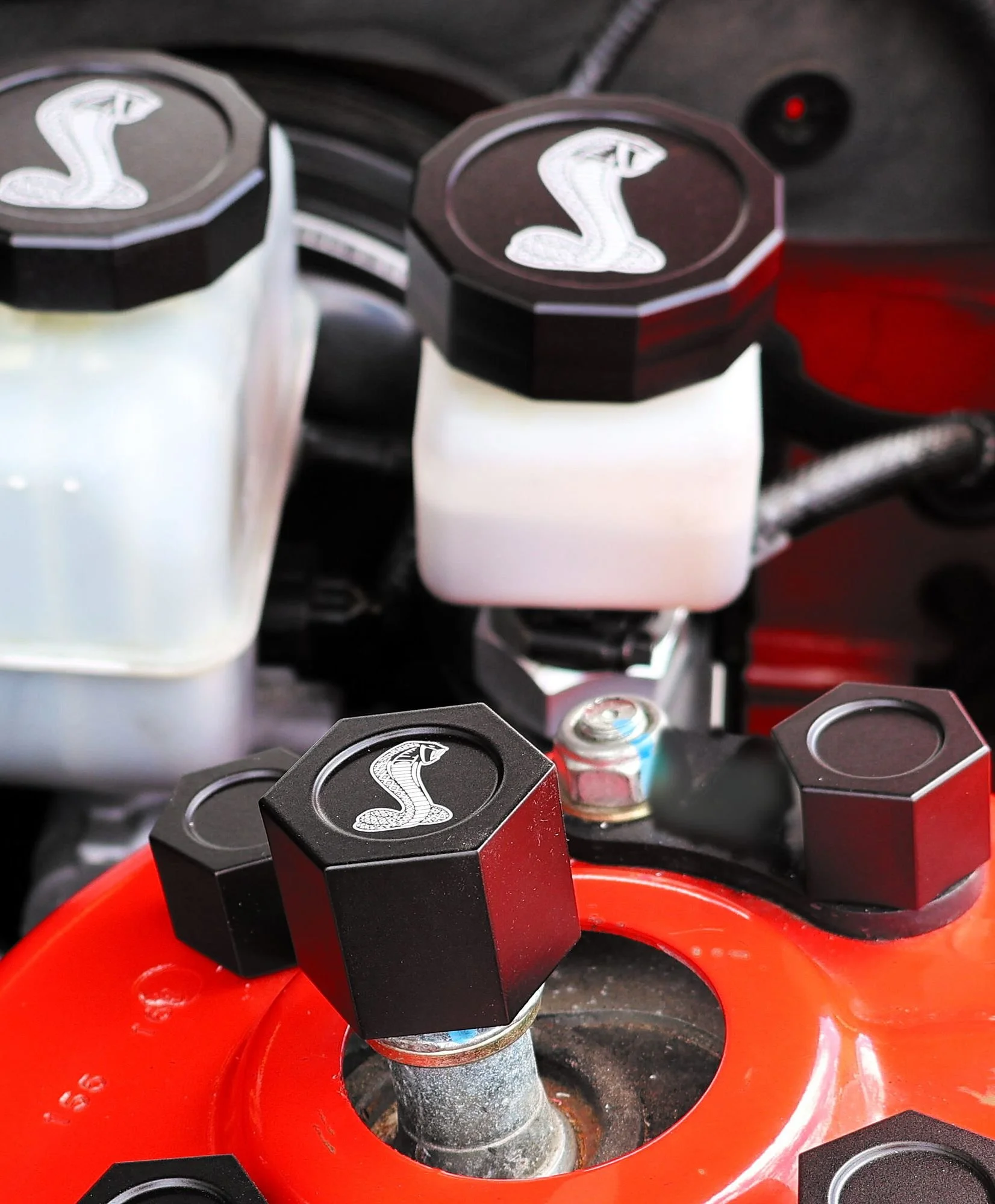 Laser engraved billet center cap installed on a GT500 shock tower below the brake and clutch reservoirs