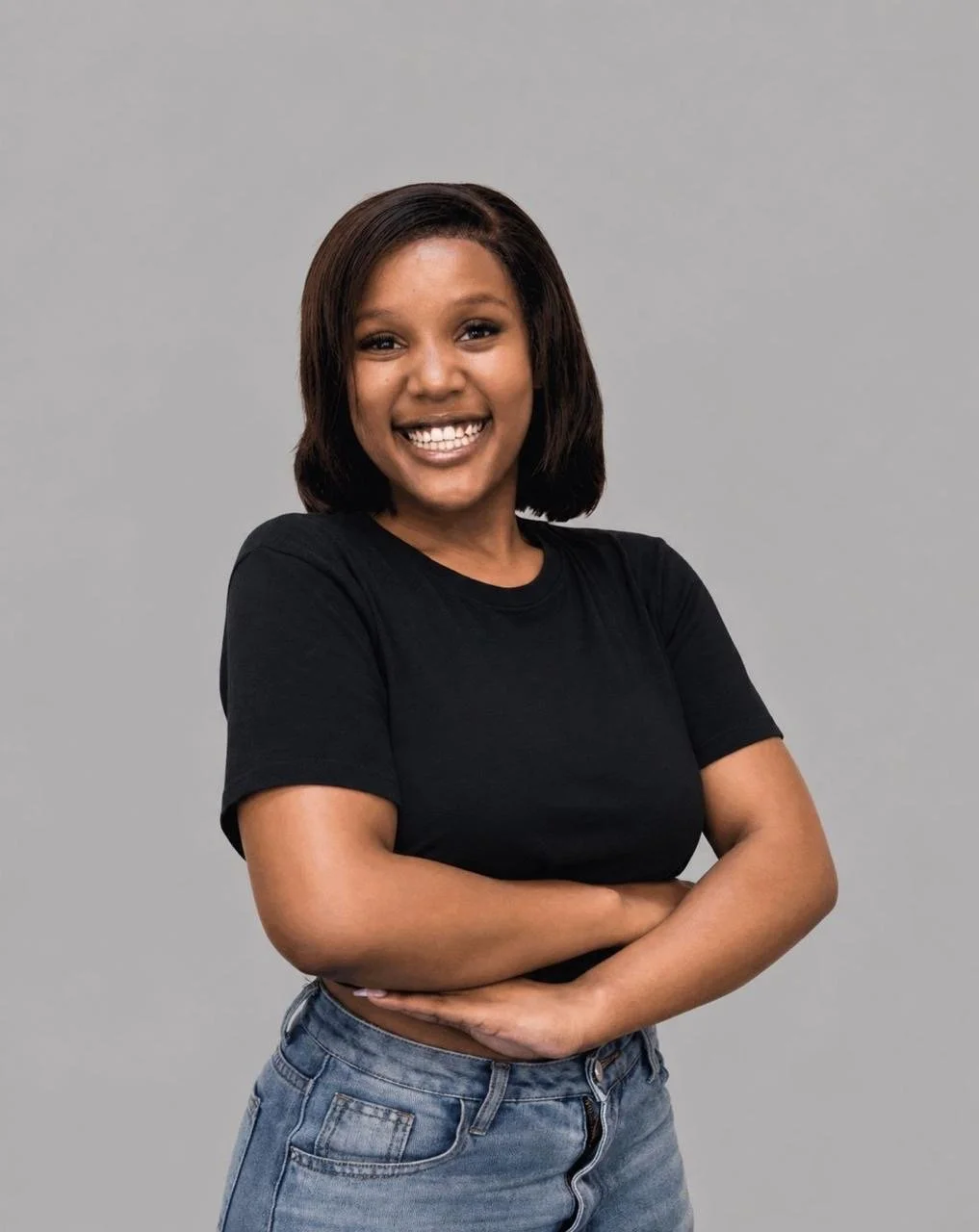 Young woman smiling, wearing a black t-shirt with a logo for the Siyanda Hadebe Foundation, standing against a plain white background.