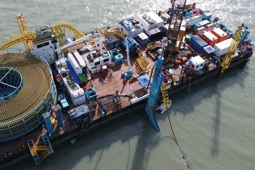 Aerial view of cable installation barge, with injector, submarine cable carousels, equipment, cabins, waterpumps