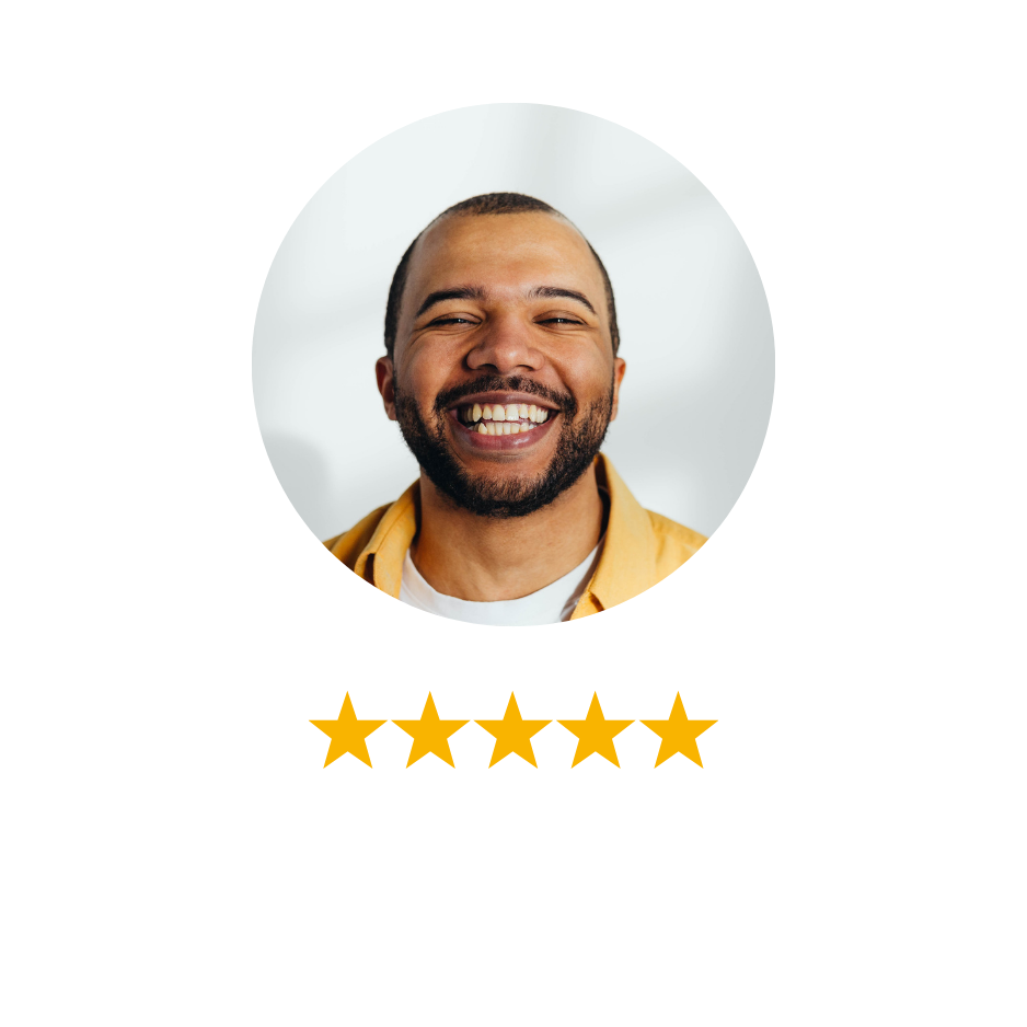 A smiling man with a beard and short hair, wearing a tan shirt, in a light-colored room.