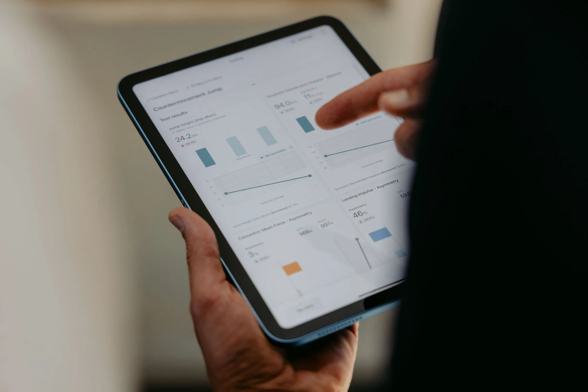 Person holding a tablet and analyzing fitness test results on the screen.