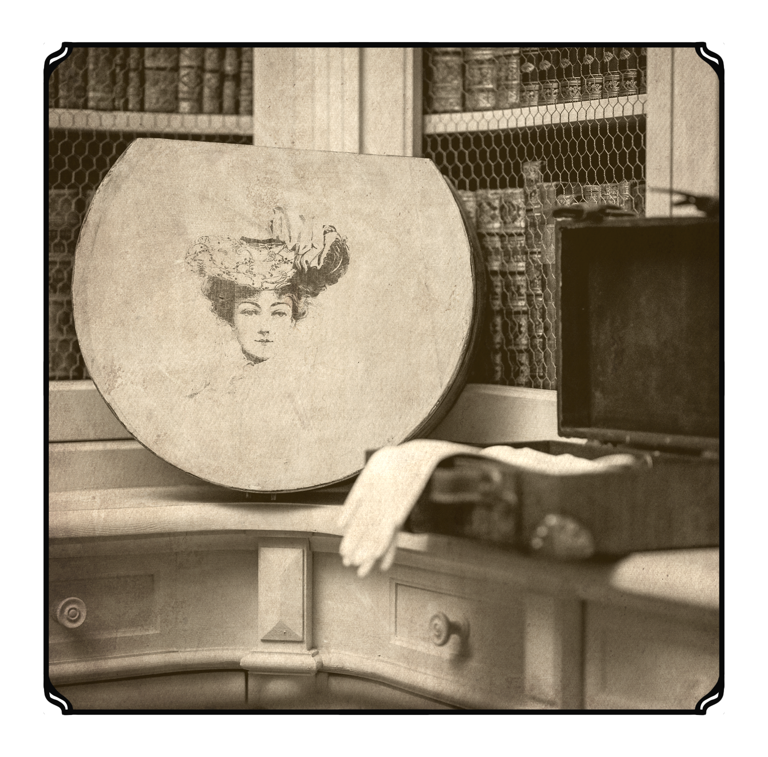 Vintage black and white photo of a round box with a woman's portrait on it, decorated with a hat. The box is placed on a surface with a curtain and a bookshelf filled with jar-like objects in the background.