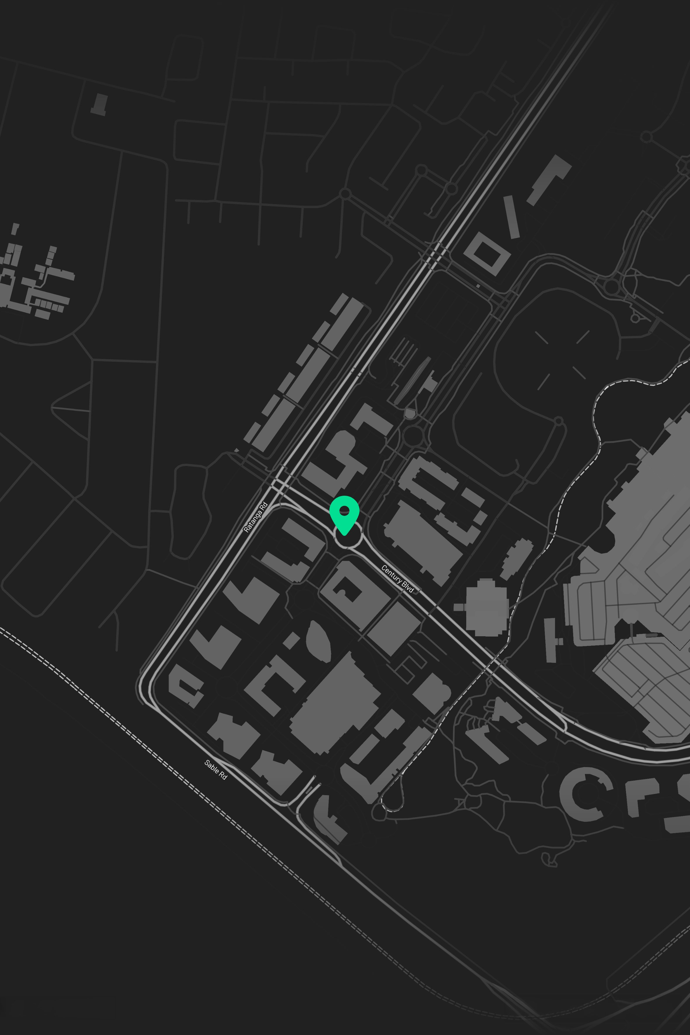 Map of a city at night showing roads and highways with a green location pin.