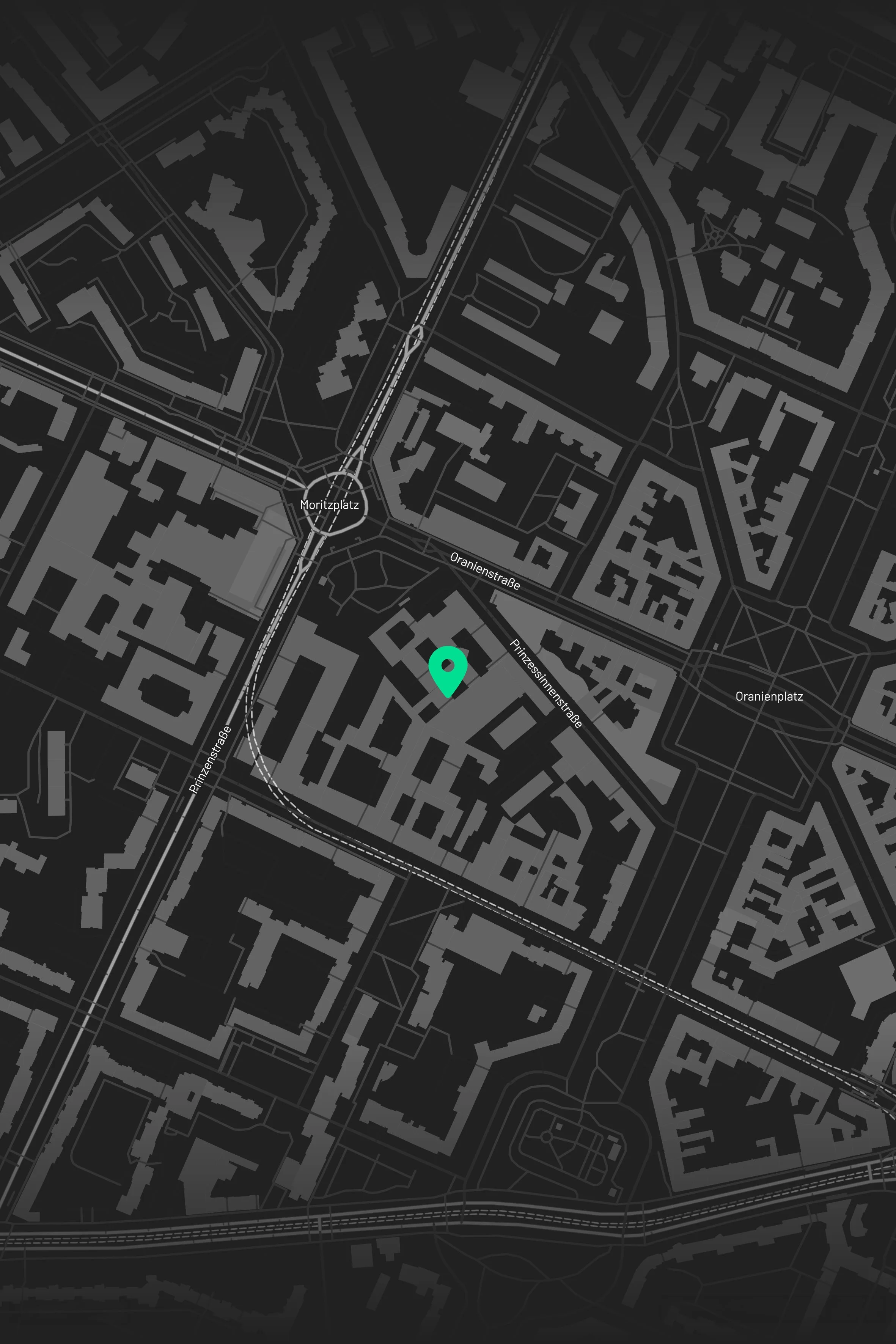 A digital map of a city at night with street details in white on a dark background, featuring a green location marker.