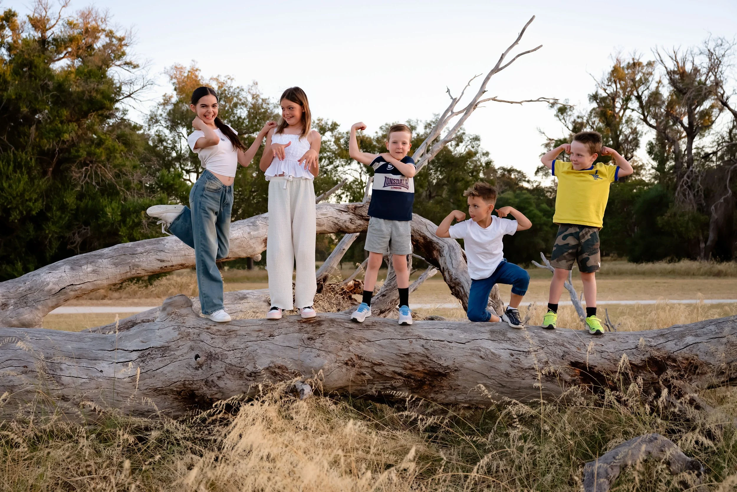 Children on a log flexing muscles