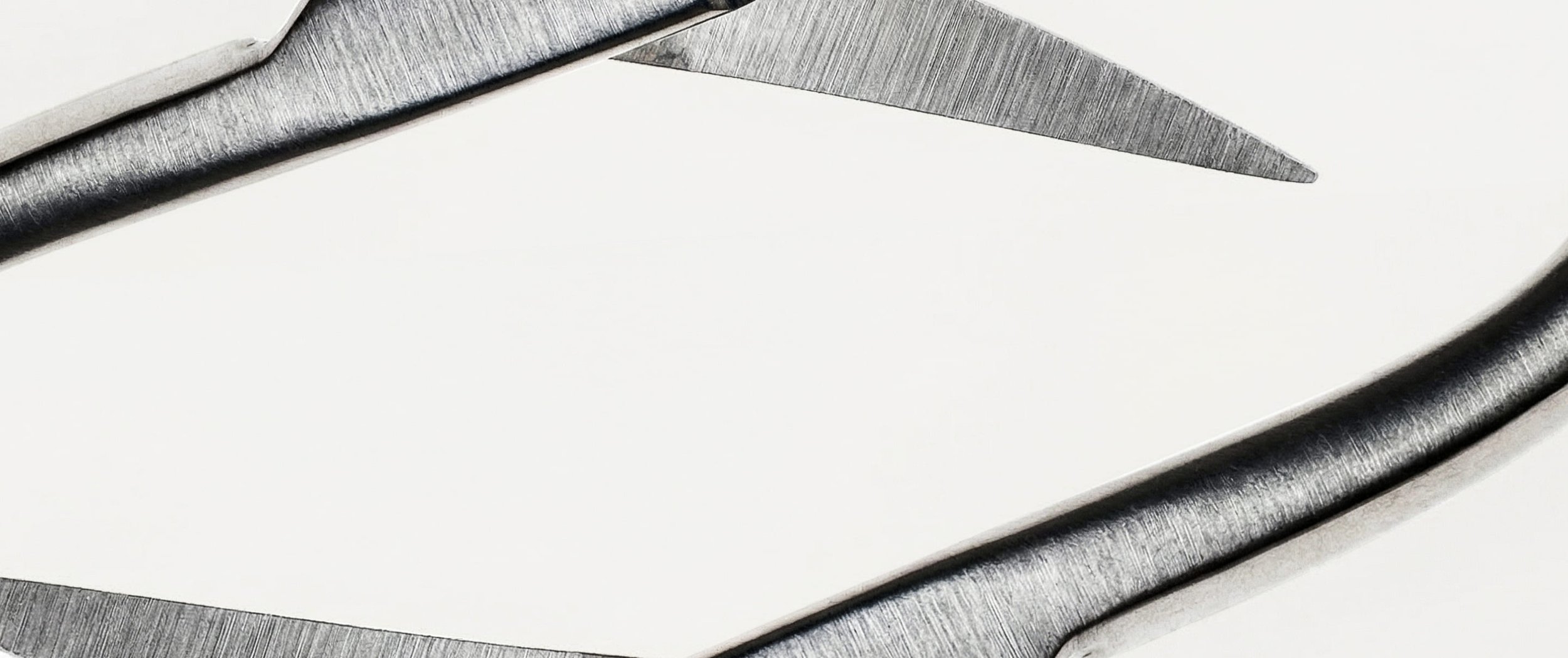 Close-up of stainless steel surgical tweezers with pointed tip against white background.
