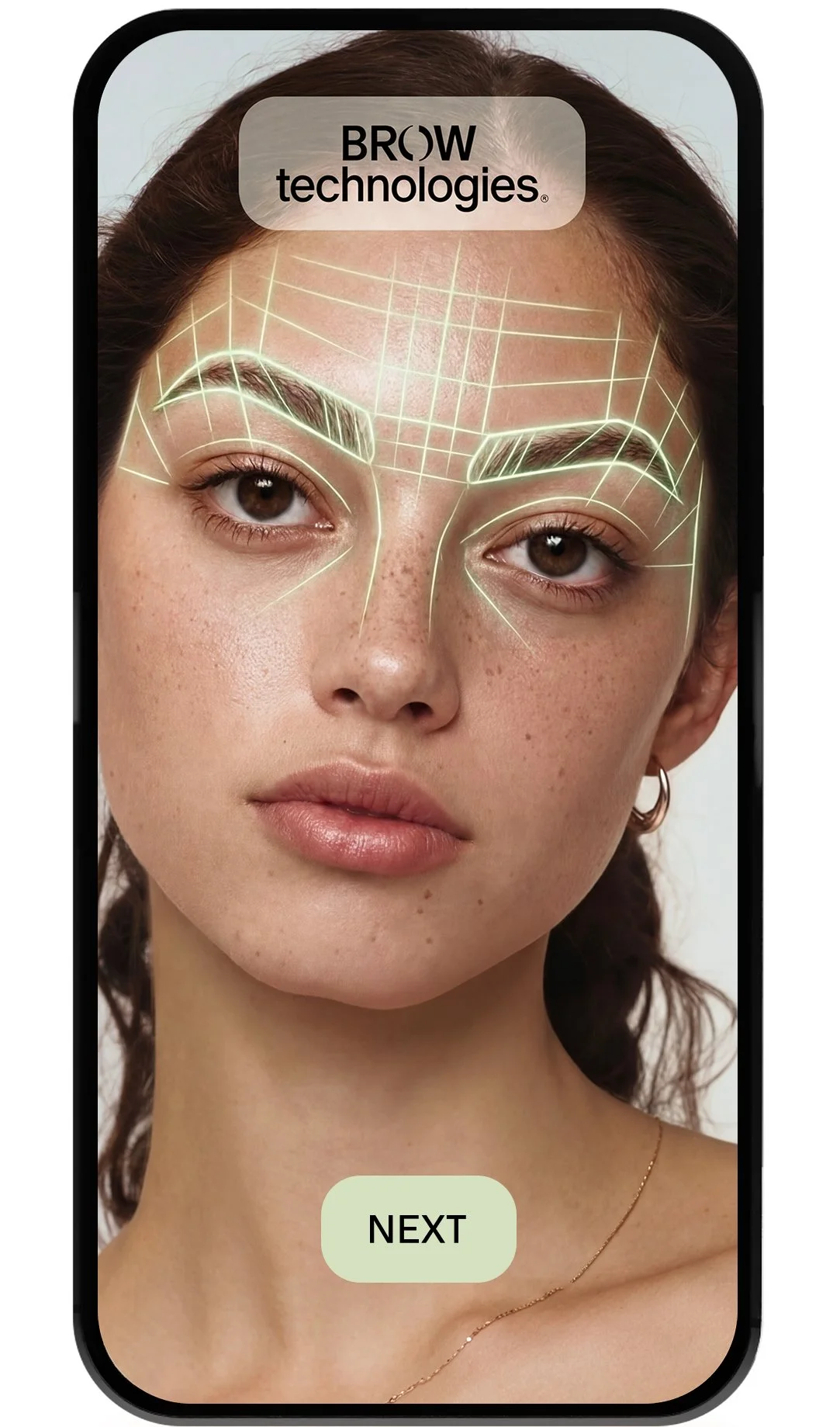 A woman with freckles and brown hair, looking at the camera, with a digital overlay of guide lines on her eyebrows and forehead, shown on a mobile phone screen with a 'NEXT' button.