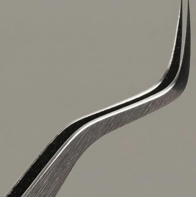Close-up of a metal fork with curved tines against a plain background.