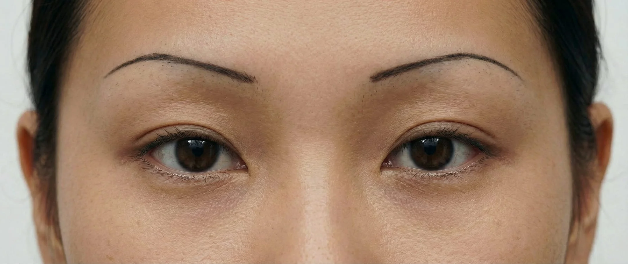 Close-up of a woman's face focusing on her eyes and eyebrows.