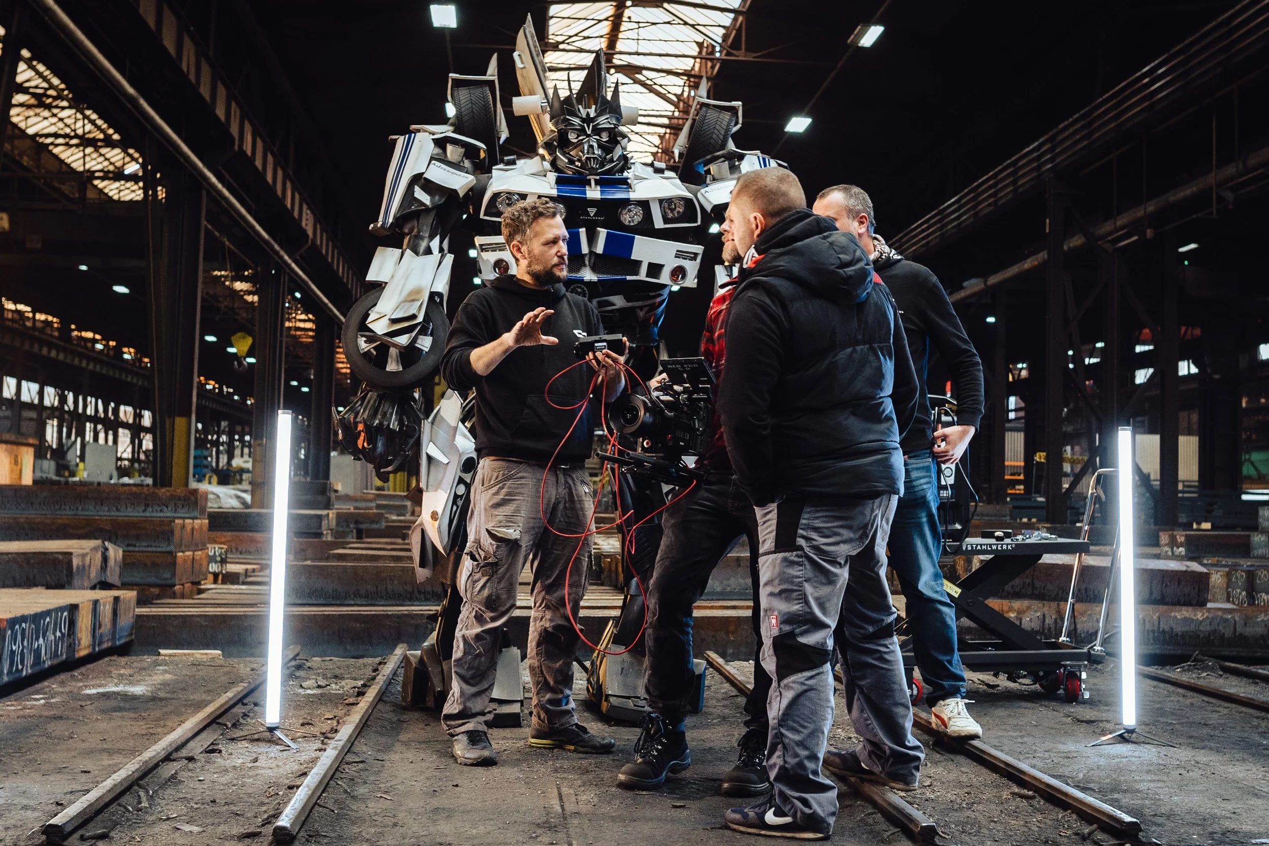 Jaco und Marvin am Set eines TV Spots. Sie führen Regie, im Hintergrund steht ein Transformer.