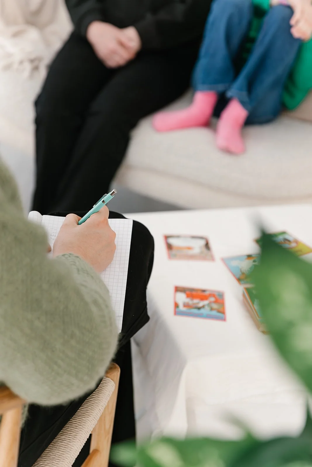 Vanhempi ja lapsi istuvat sohvalla terapeuttia vastapäätä.