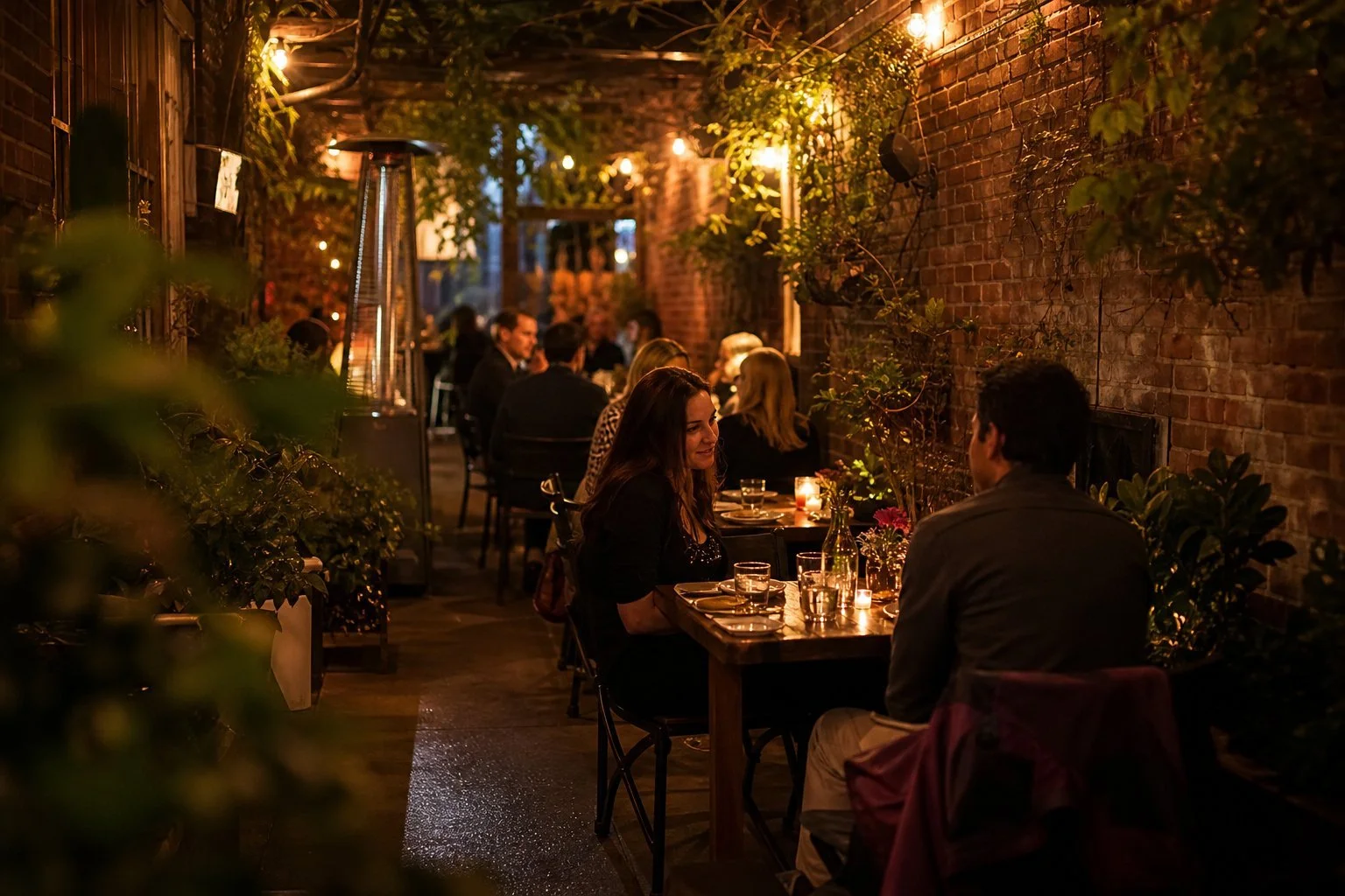 Small cosy New York City restaurant with diners at wooden tables, exposed brick walls and warm lighting