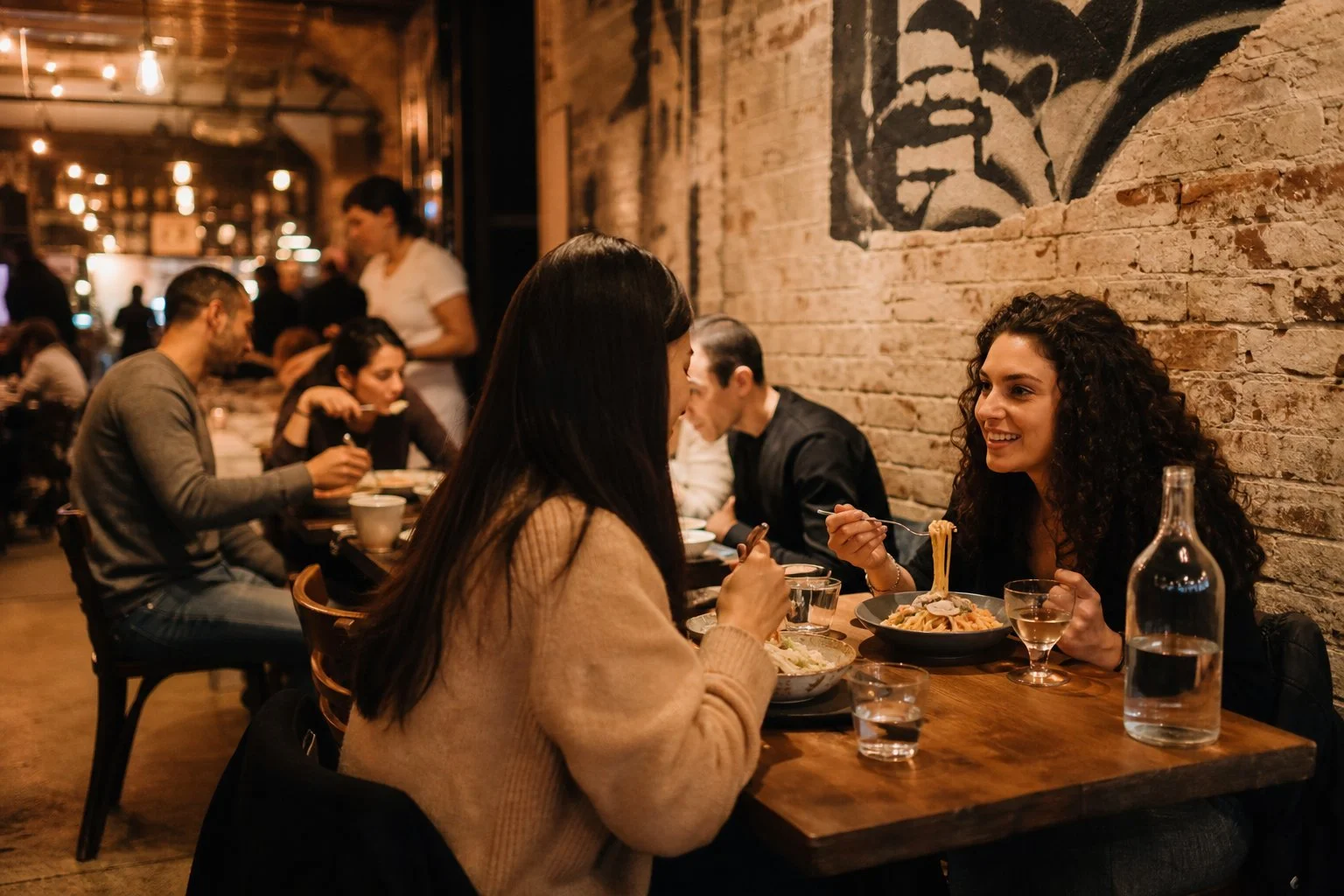 Cosy outdoor dining area on a quiet New York street with people eating at tables under warm lighting