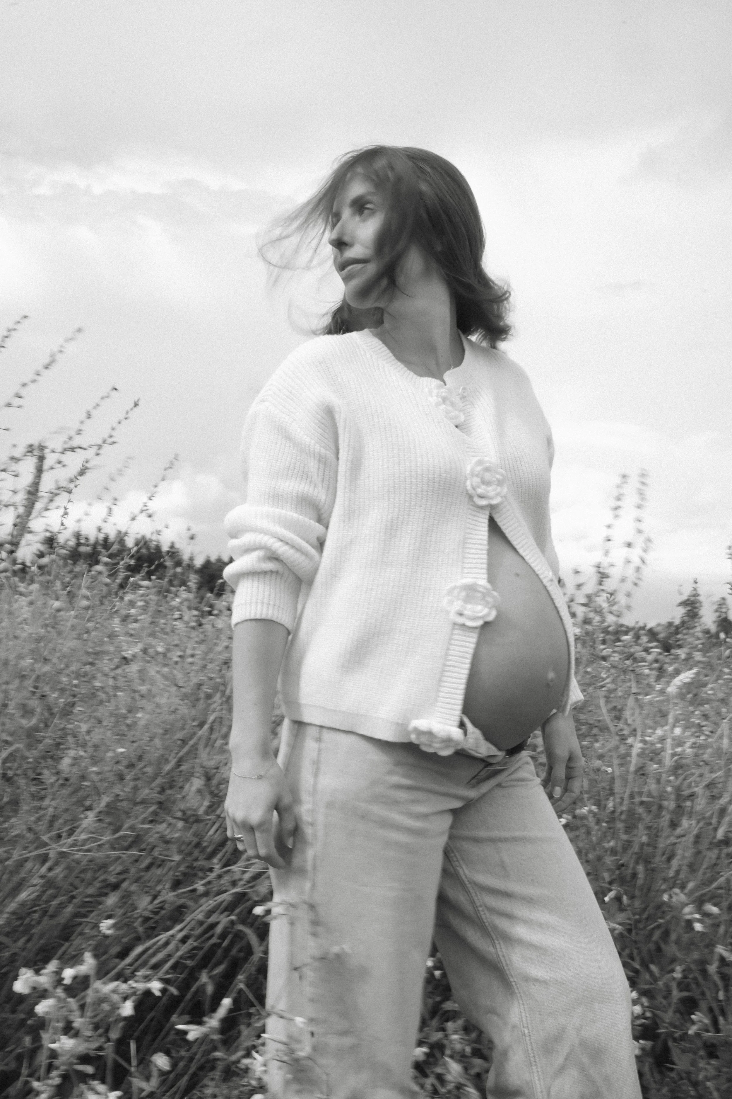 Porträt einer schwangeren Frau auf einer Blumenwiese, fotografiert von Fotografin Salome Peter
