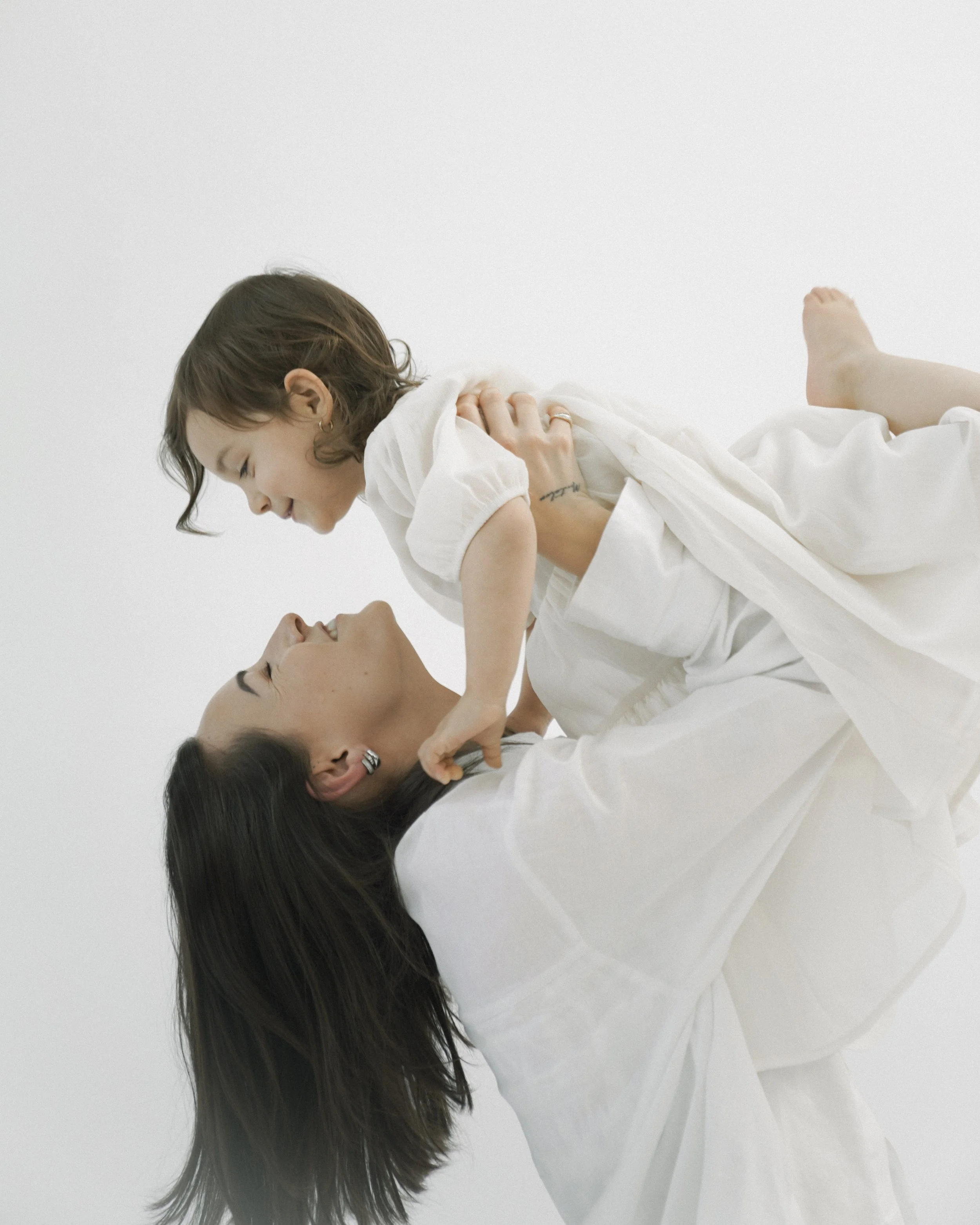 Studio-Familienportrait einer jungen Mutter mit Kind vor neutralem Hintergrund, fotografiert von Fotografin Salome Peter in Wil