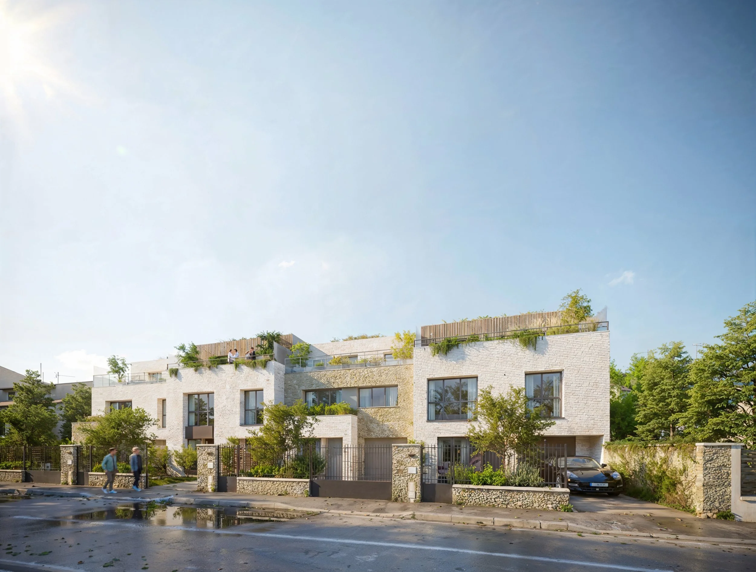 Immeuble résidentiel moderne avec toit terrasse végétalisé, arbres et voitures garées devant, ciel clair.