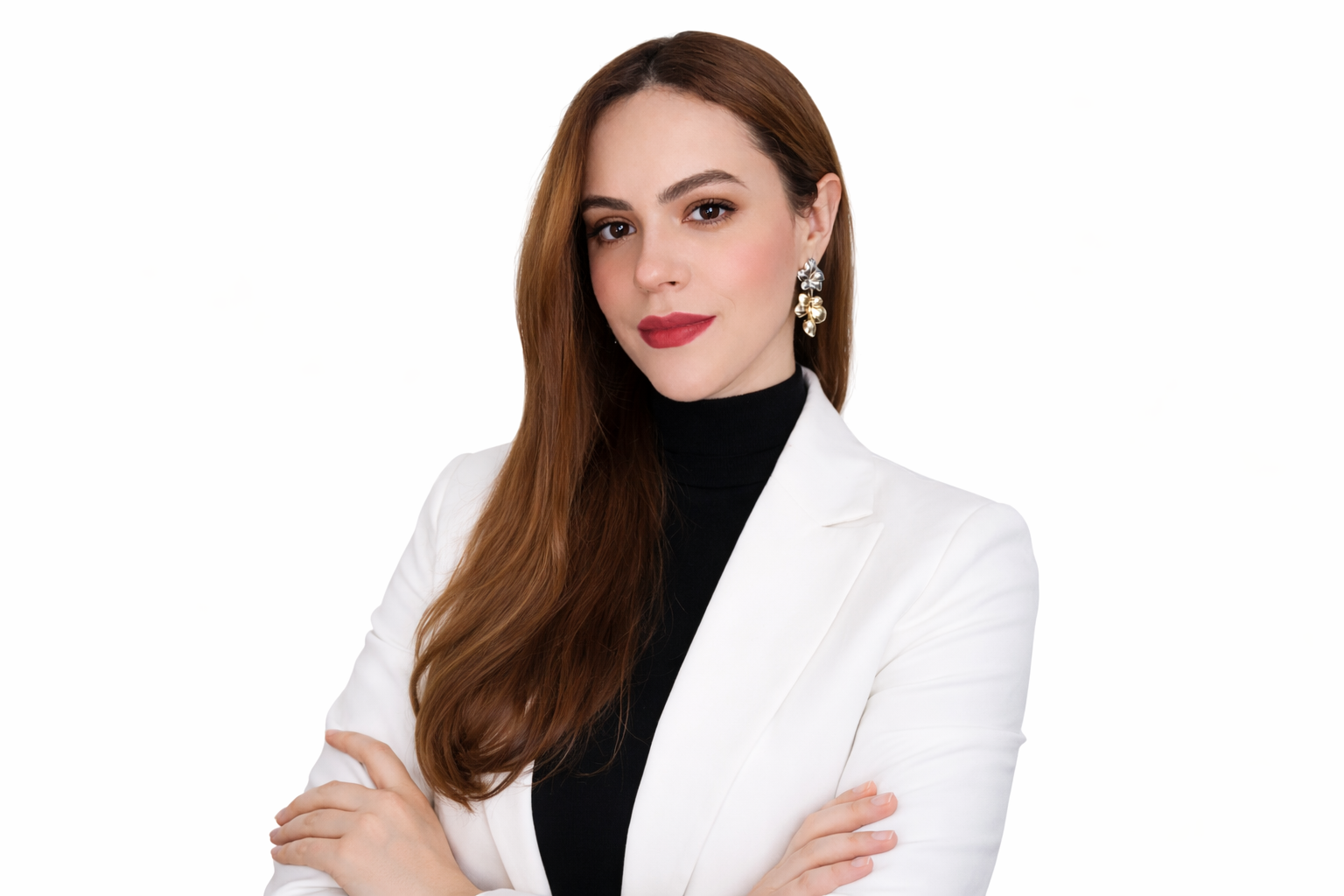 Mulher com cabelo castanho, vestindo terno branco e blusa preta, com brincos grandes de flor, olhando para a câmera com braços cruzados.