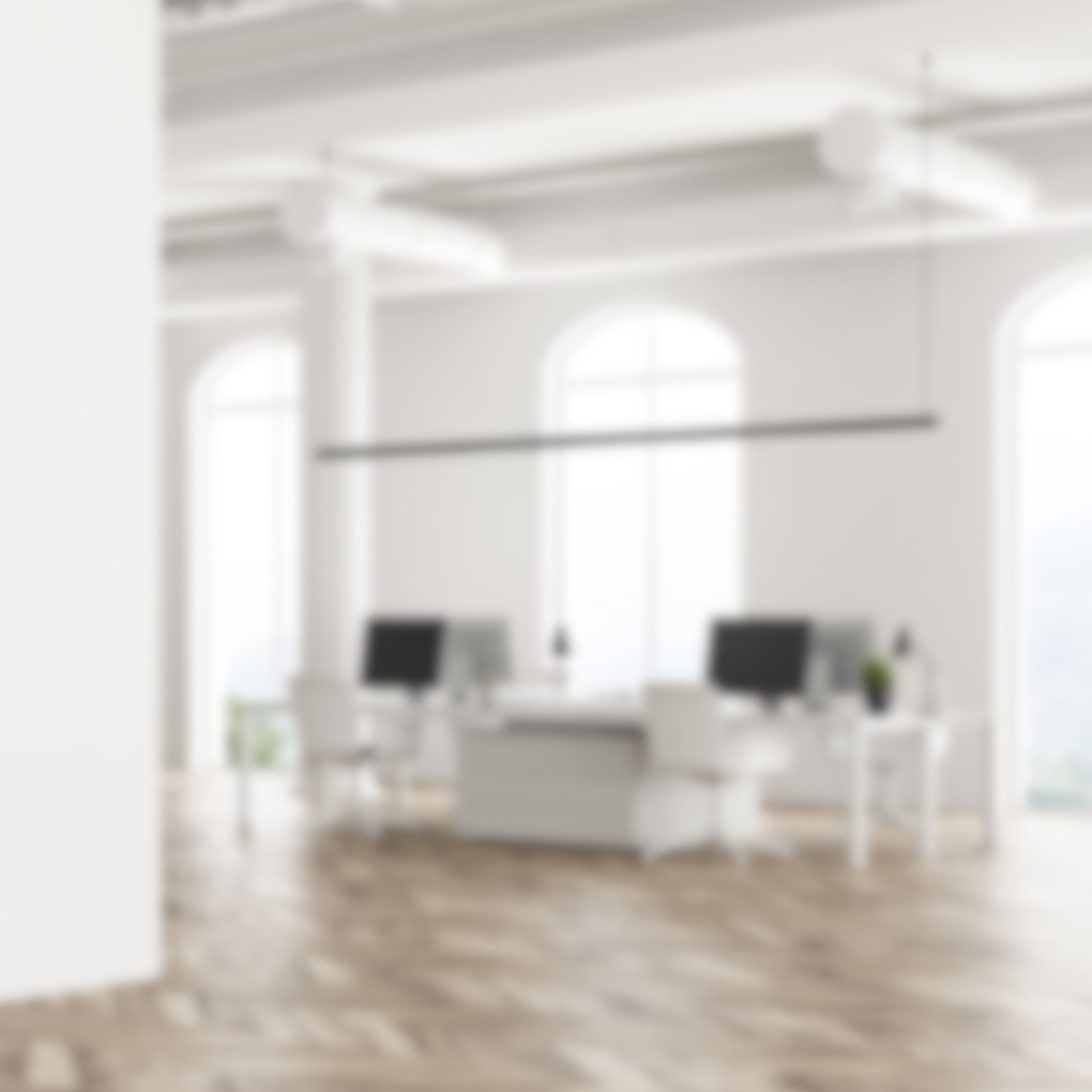 Escritório moderno com duas mesas de trabalho, cadeiras brancas, computadores, janelas grandes e piso de madeira.