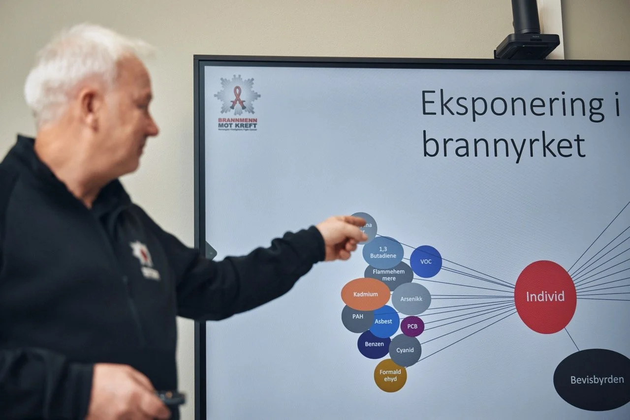 En mann peker ved en digital skjerm som viser et diagram om eksponering i brannrøret, med navn på ulike kjemikalier og påvirkning av individer og bevisbyrden.