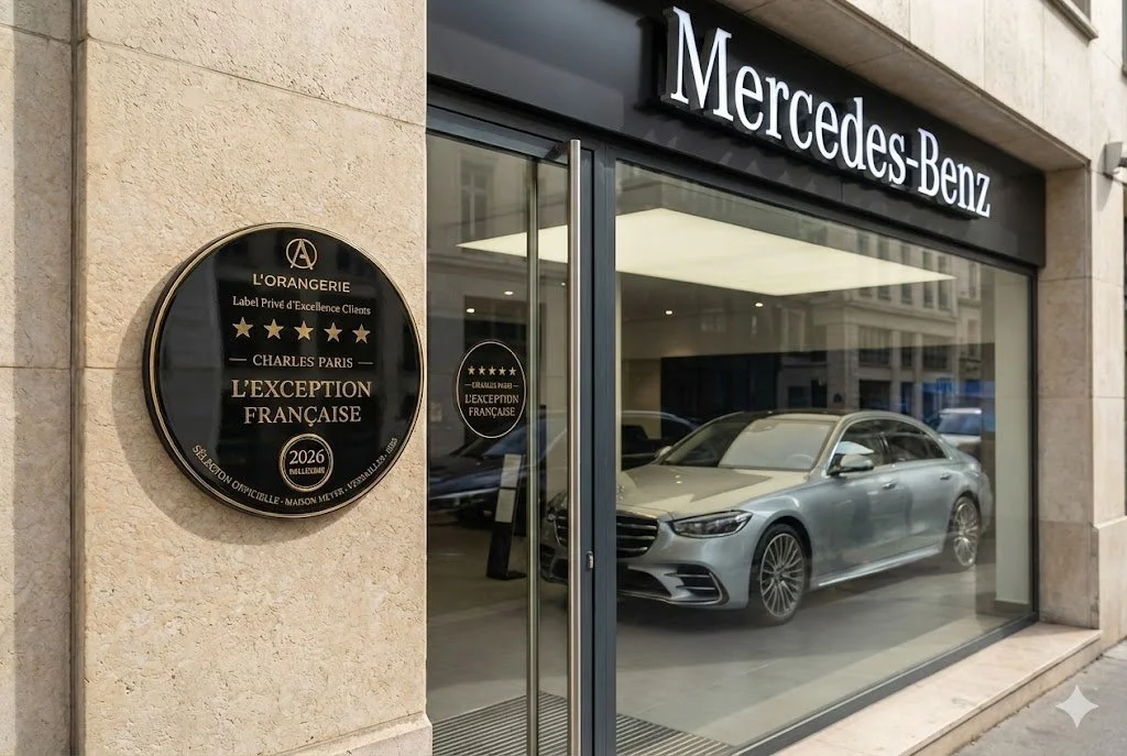 Vitrine d'une concession Mercedes-Benz avec une voiture Mercedes argentée à l'intérieur, façade en verre, et des plaques de reconnaissance à gauche.