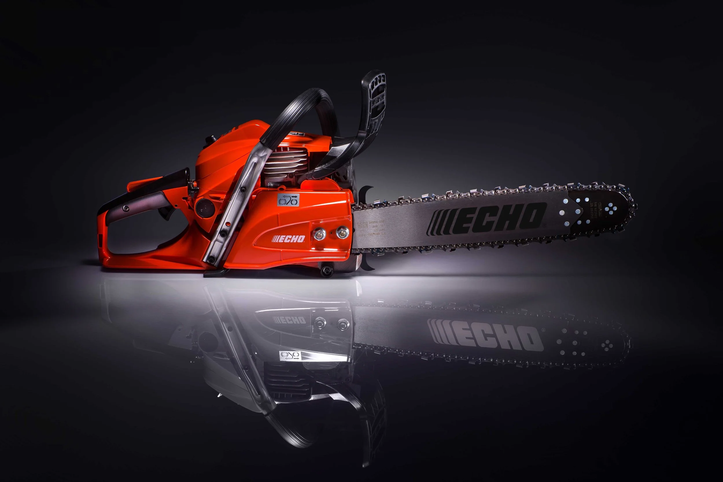 Profesionalna motorna žaga ECHO CS-501SX v studijskem okolju, prikazana s strani, z izrazitim oranžnim ohišjem in vodilno ploščo ECHO, namenjena zahtevnim gozdarskim delom.