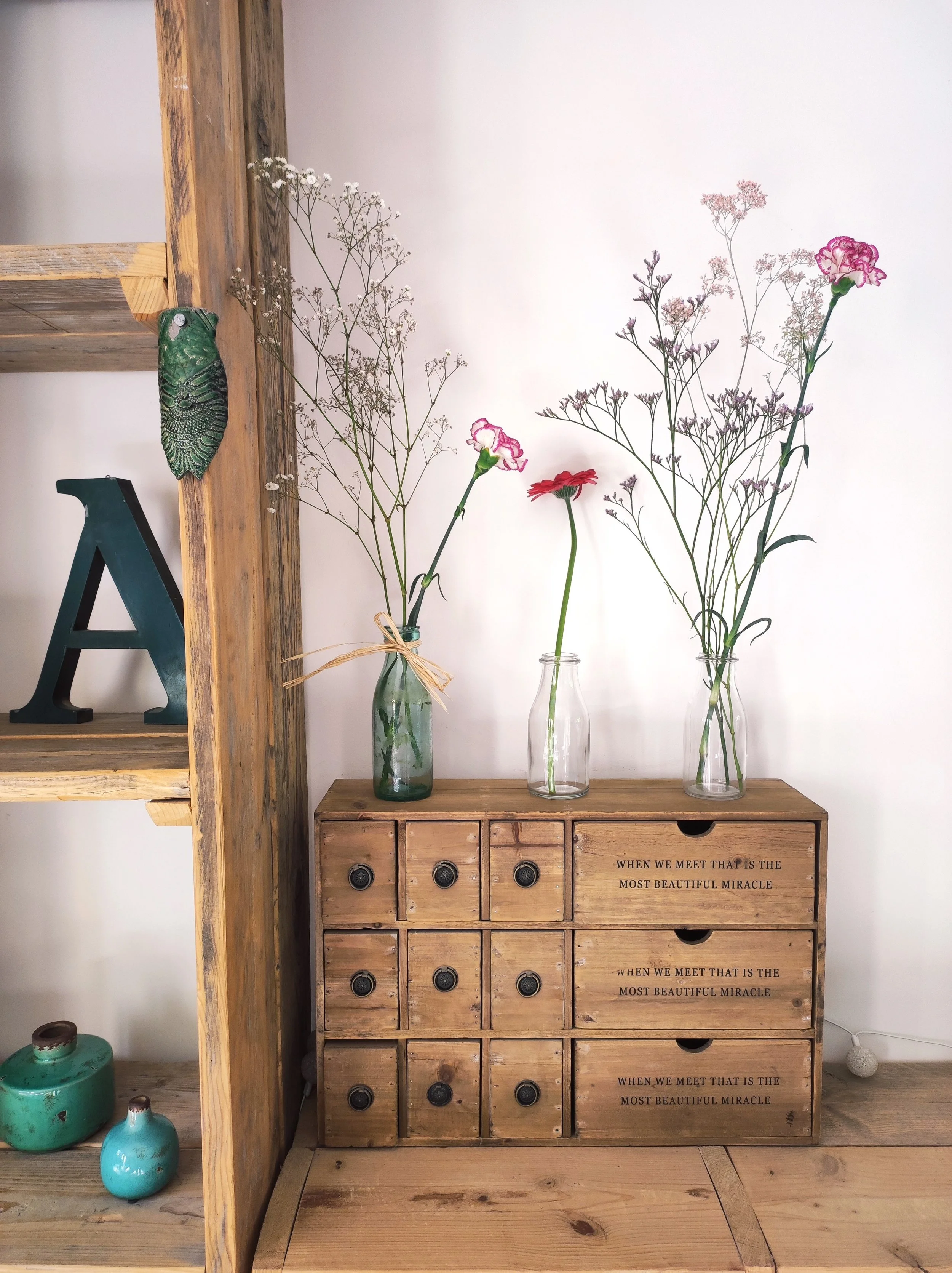 meuble chiné avec vases bouteille fleurs cigale et lettre d'imprimerie trouvée en brocante à velaux
