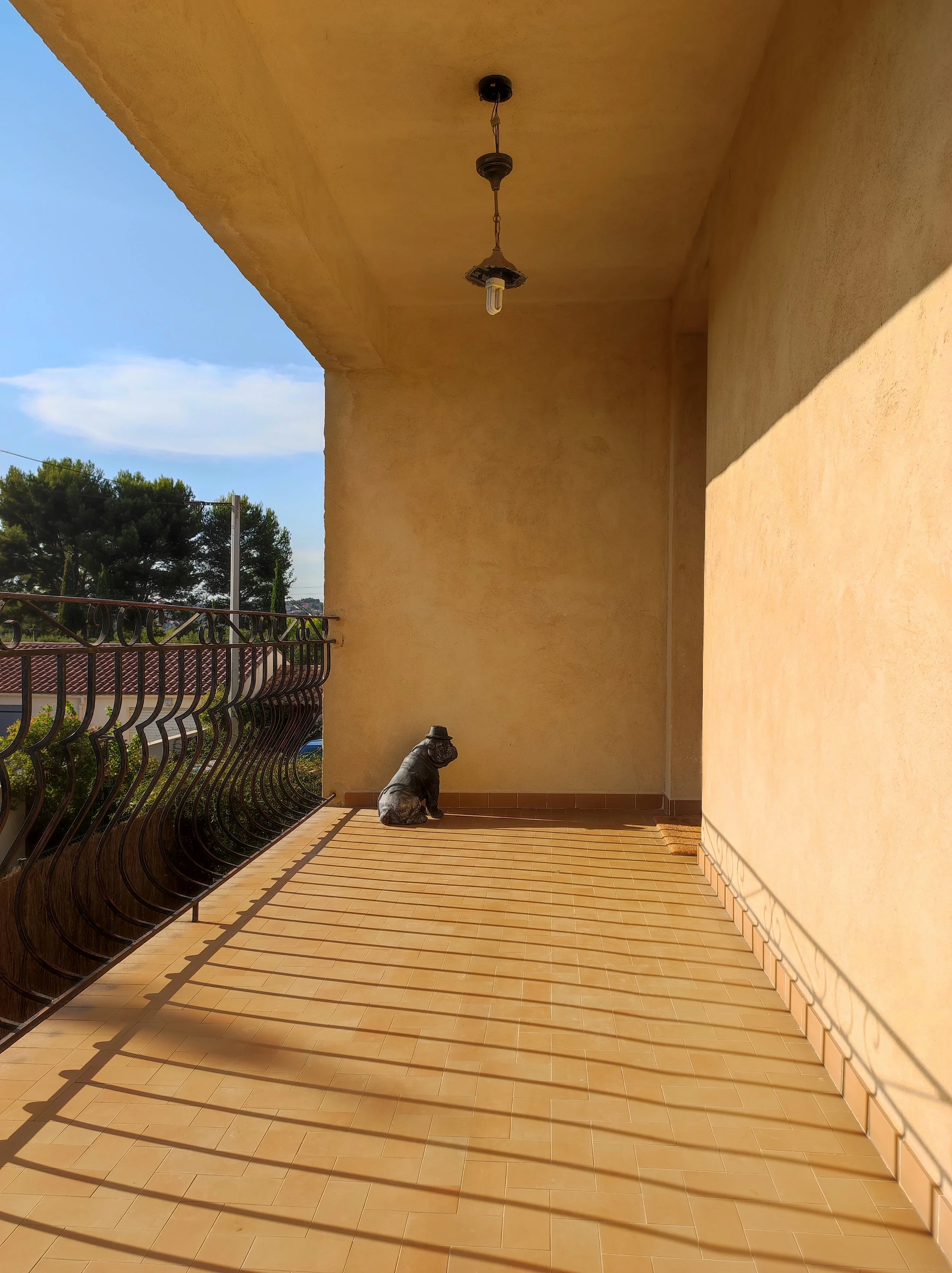 Avant : Terrasse devant une porte d'entrée, sans charme et sans utilité