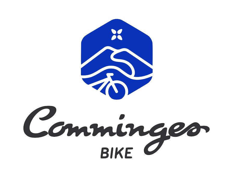 Logo de Commincer Bike avec un emblème en forme de hexagone bleu représentant une montagne, une rivière et une bicyclette, avec le texte 'Commincer' en script noir et 'BIKE' en majuscules gris.