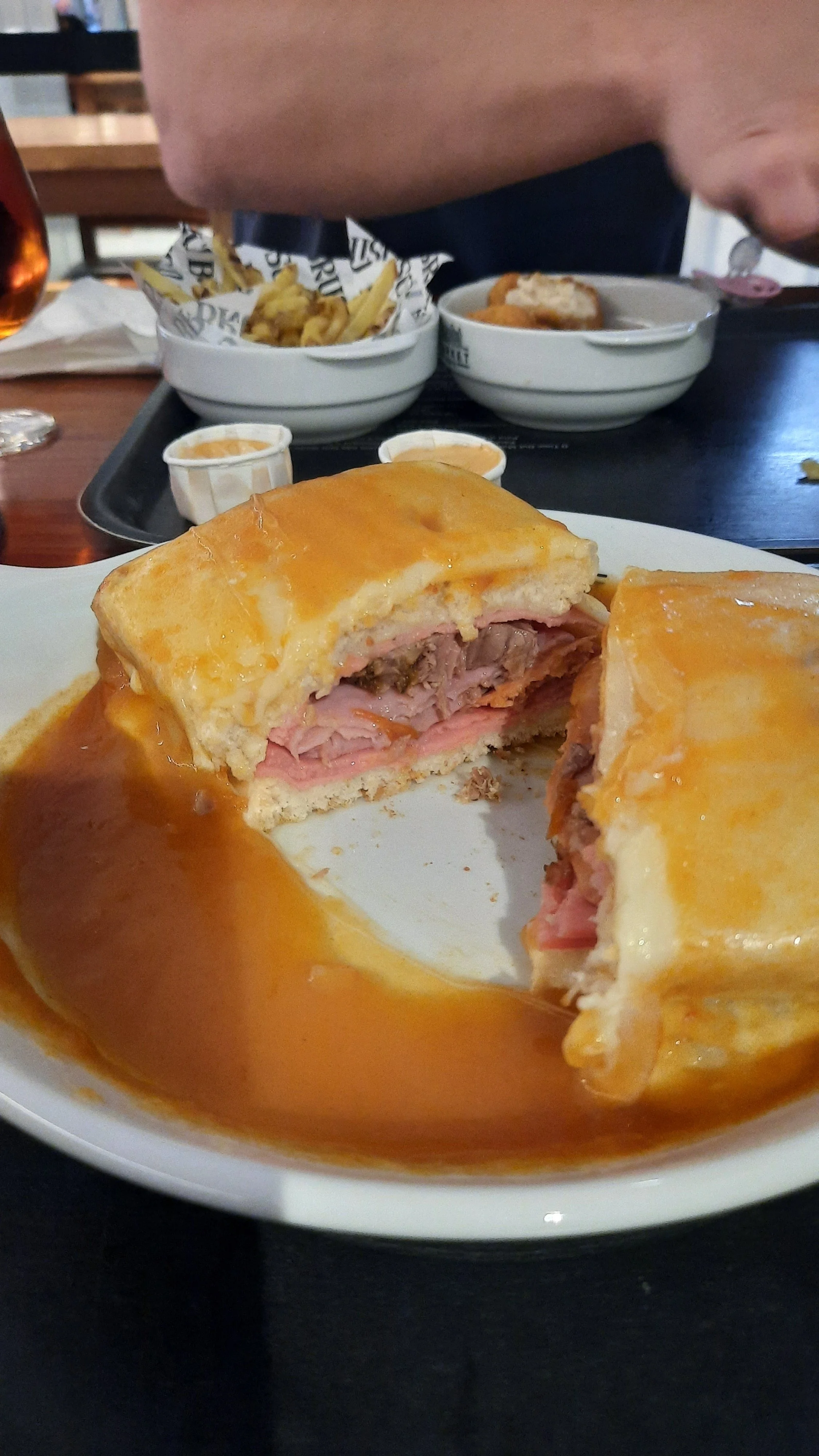 Un plat de Yorkshire pudding farci de viande et nappé de sauce, servi dans une assiette blanche.