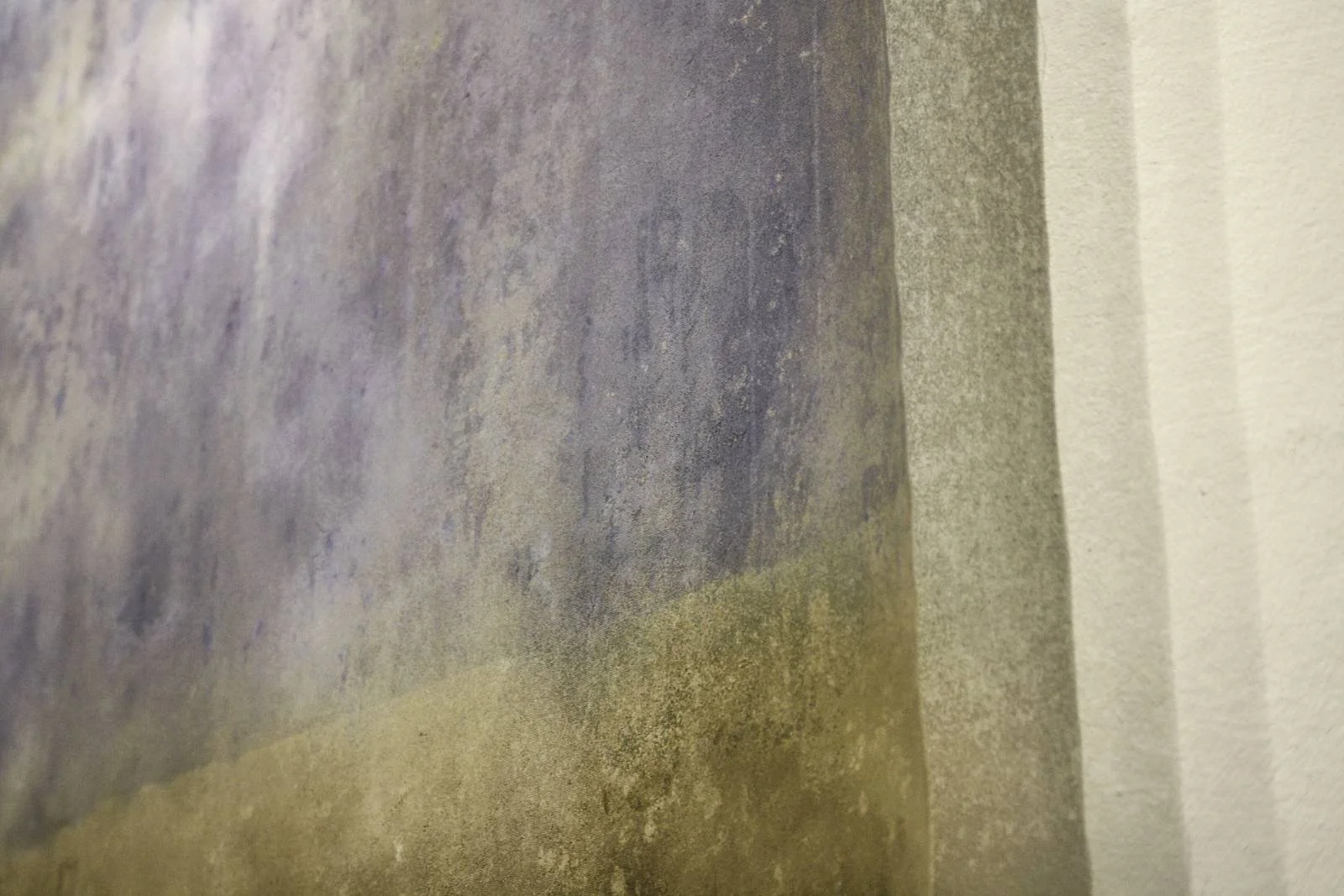 Close-up of a gray concrete surface with texture and color variations.