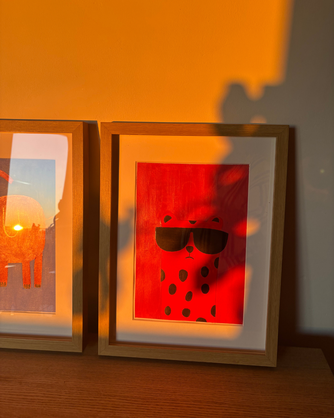 Photo de deux cadres avec des illustrations, une avec un animal avec des lunettes de soleil et une autre avec un animal de couleur orange.