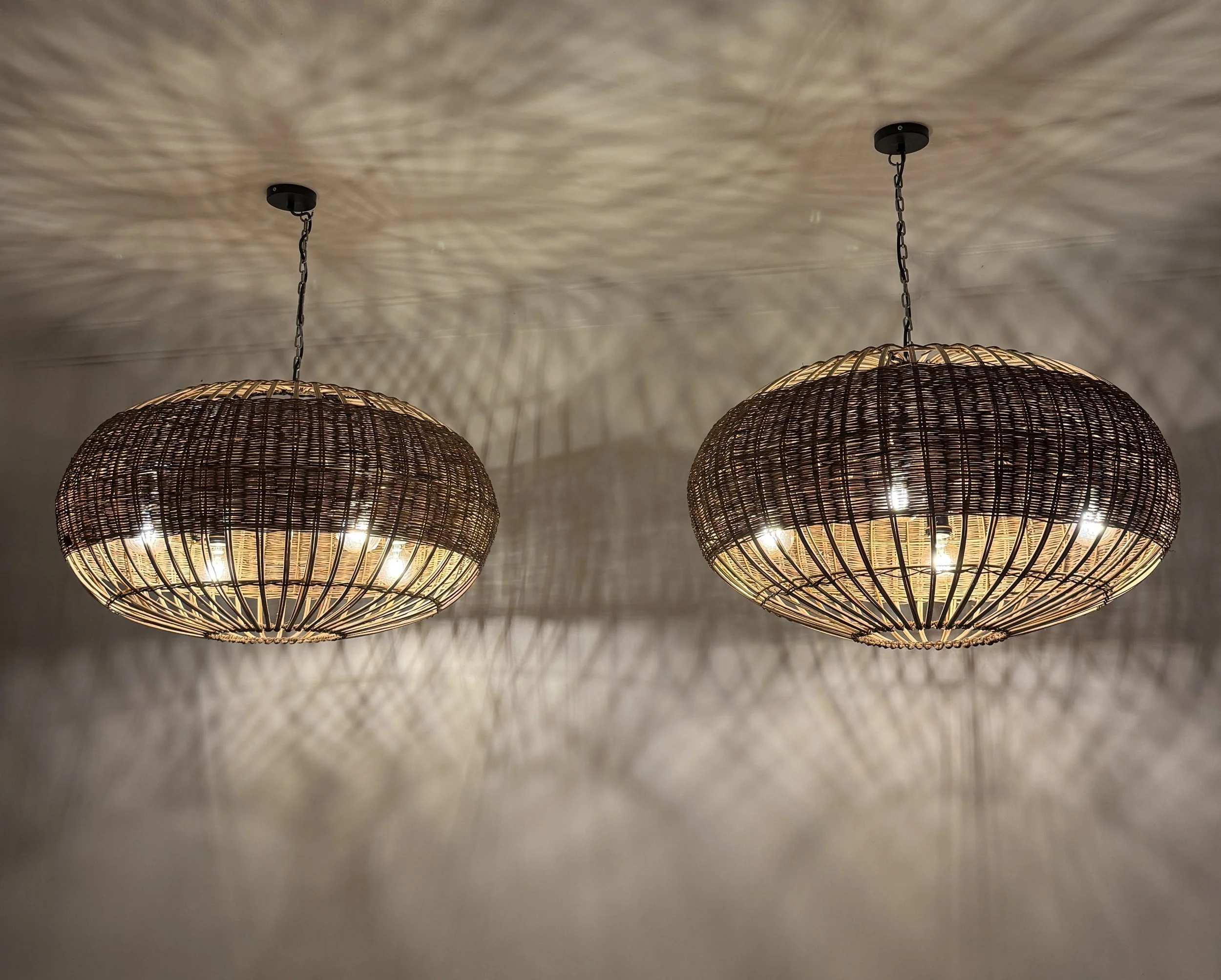 Two woven rings suspended together, creating a balanced blend of symmetry, texture, and ambient light for contemporary interiors.