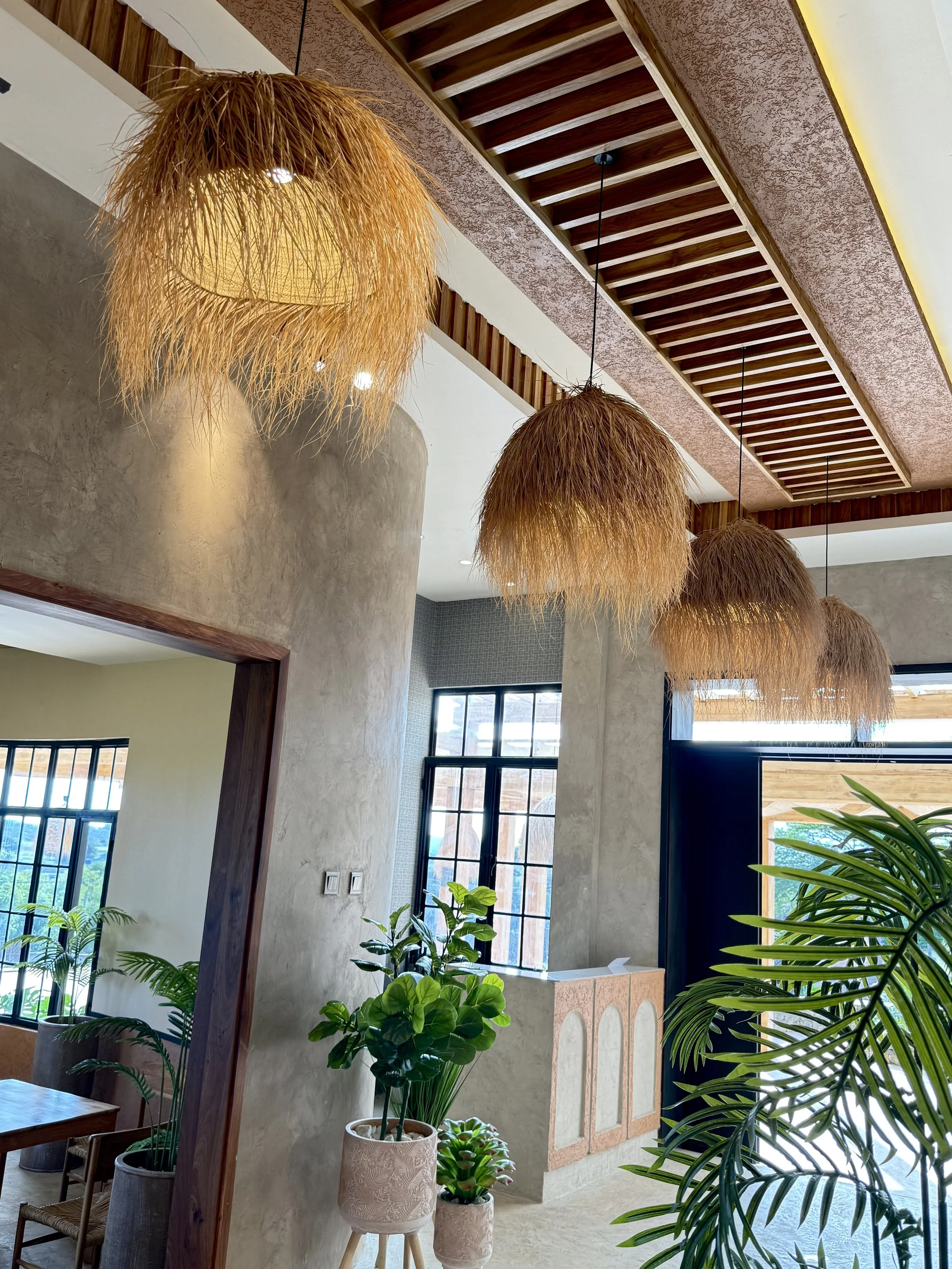 A dramatic arrangement of natural woven ukili pendants that brings texture, depth, and artisanal charm to large spaces and hospitality interiors.