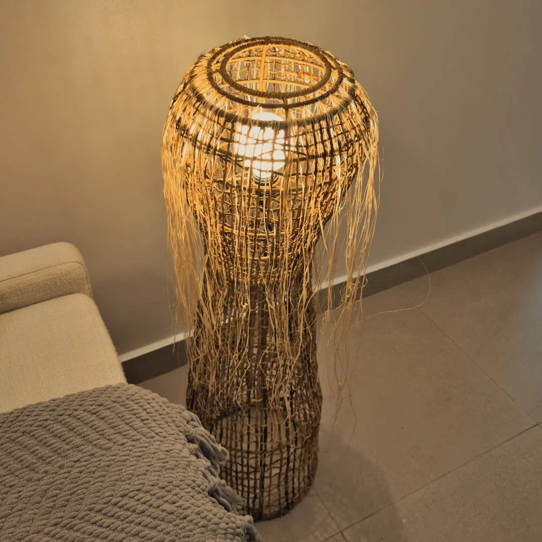 A tall, handcrafted floor light that softly illuminates surrounding spaces, perfect for bedrooms or living areas seeking ambient charm.