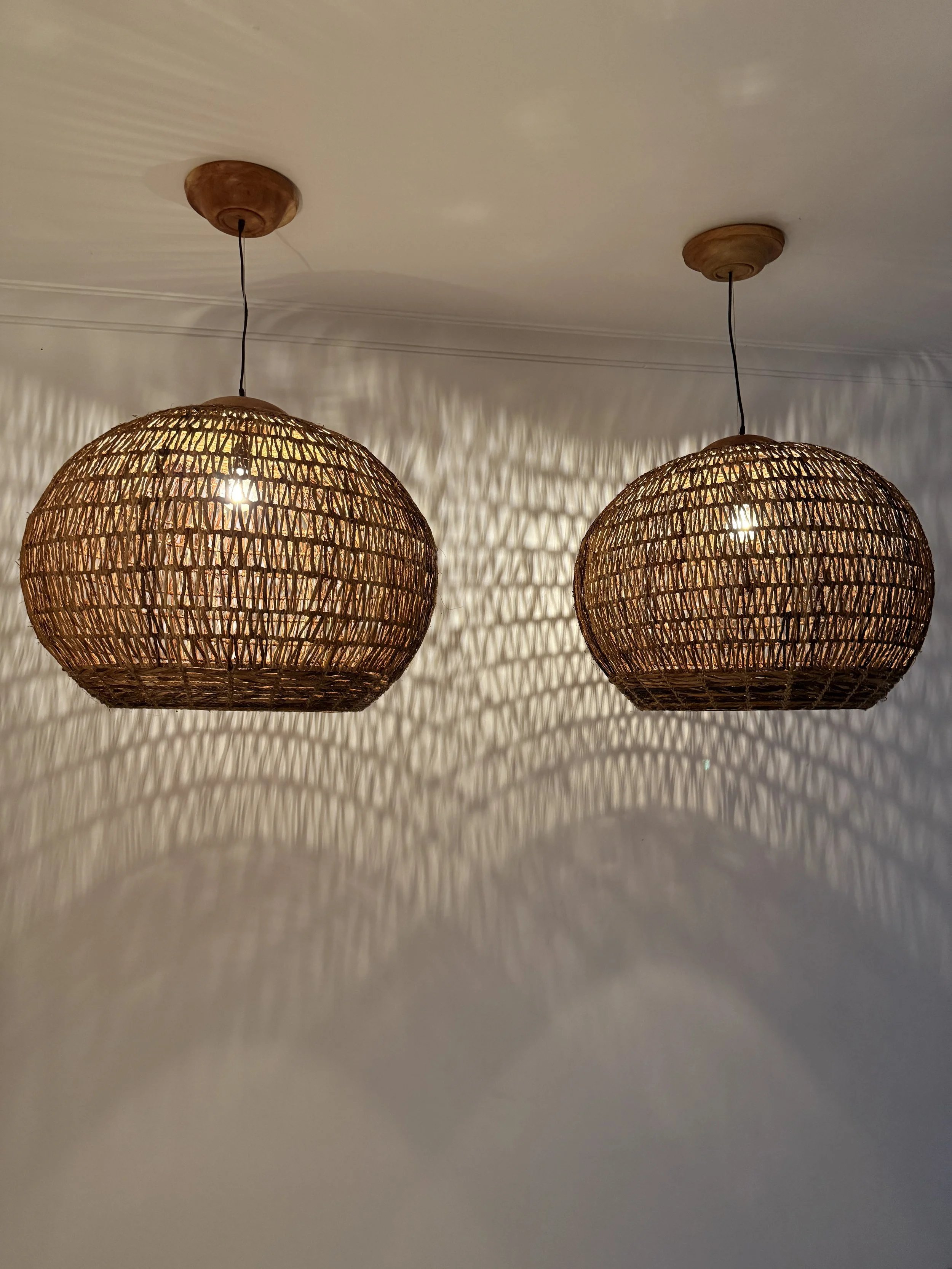 Handwoven dome pendants that cast intricate shadow patterns, bringing balance, warmth, and artisanal character to dining or living areas.