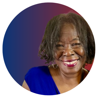 A woman with short, curly hair smiling and wearing a blue top.
