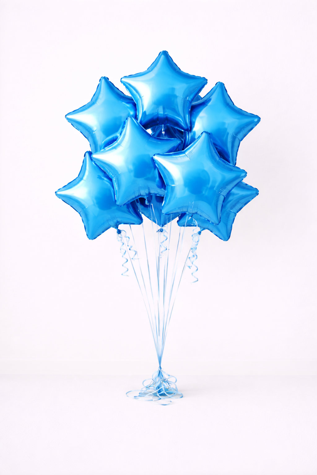 A bunch of blue star-shaped balloons tied together and floating against a plain white background.