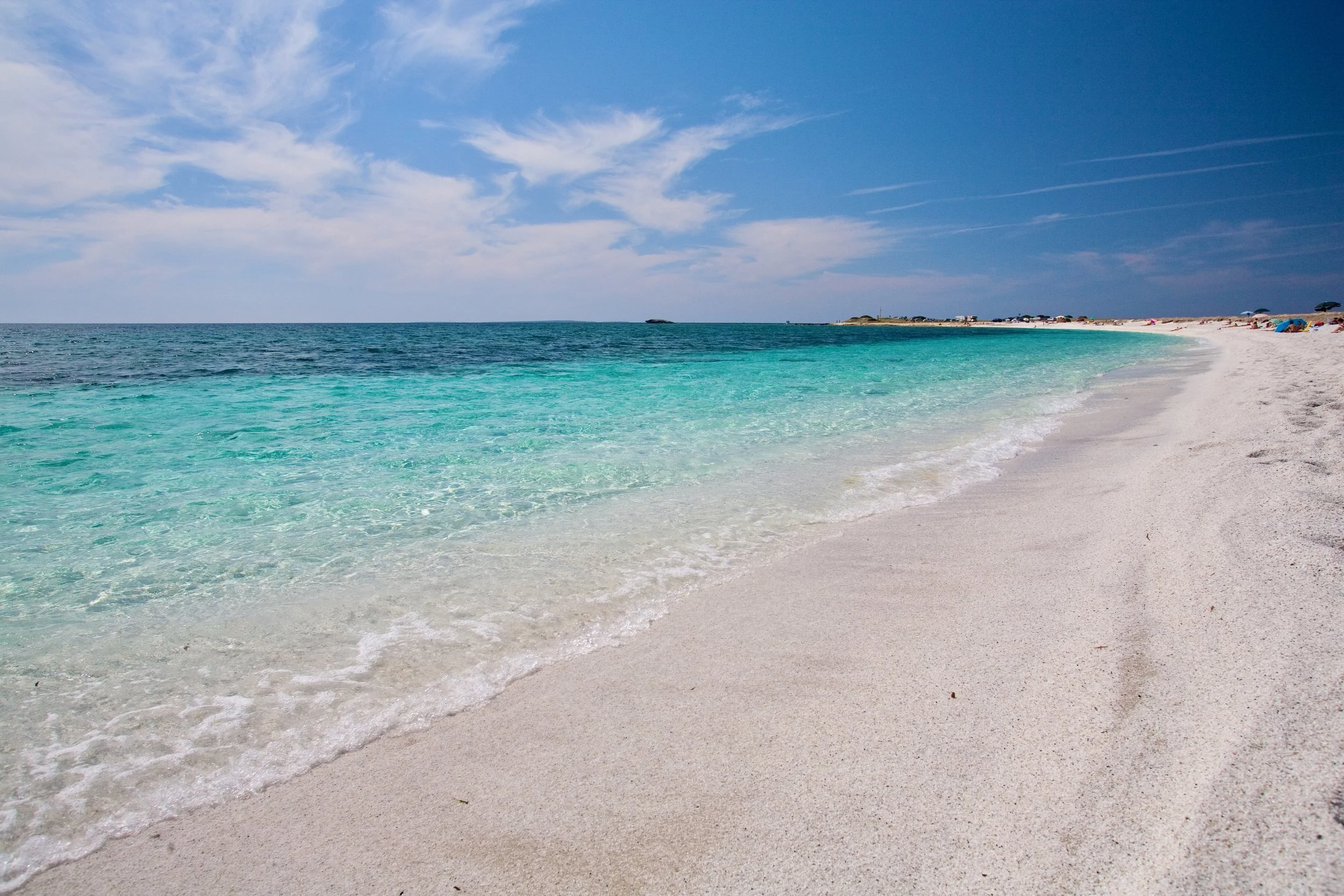 Oristano, Sardinia - Sinis Peninsula - Mari Ermi's quartz beach with turquoise water and a blue sky with white clouds.
