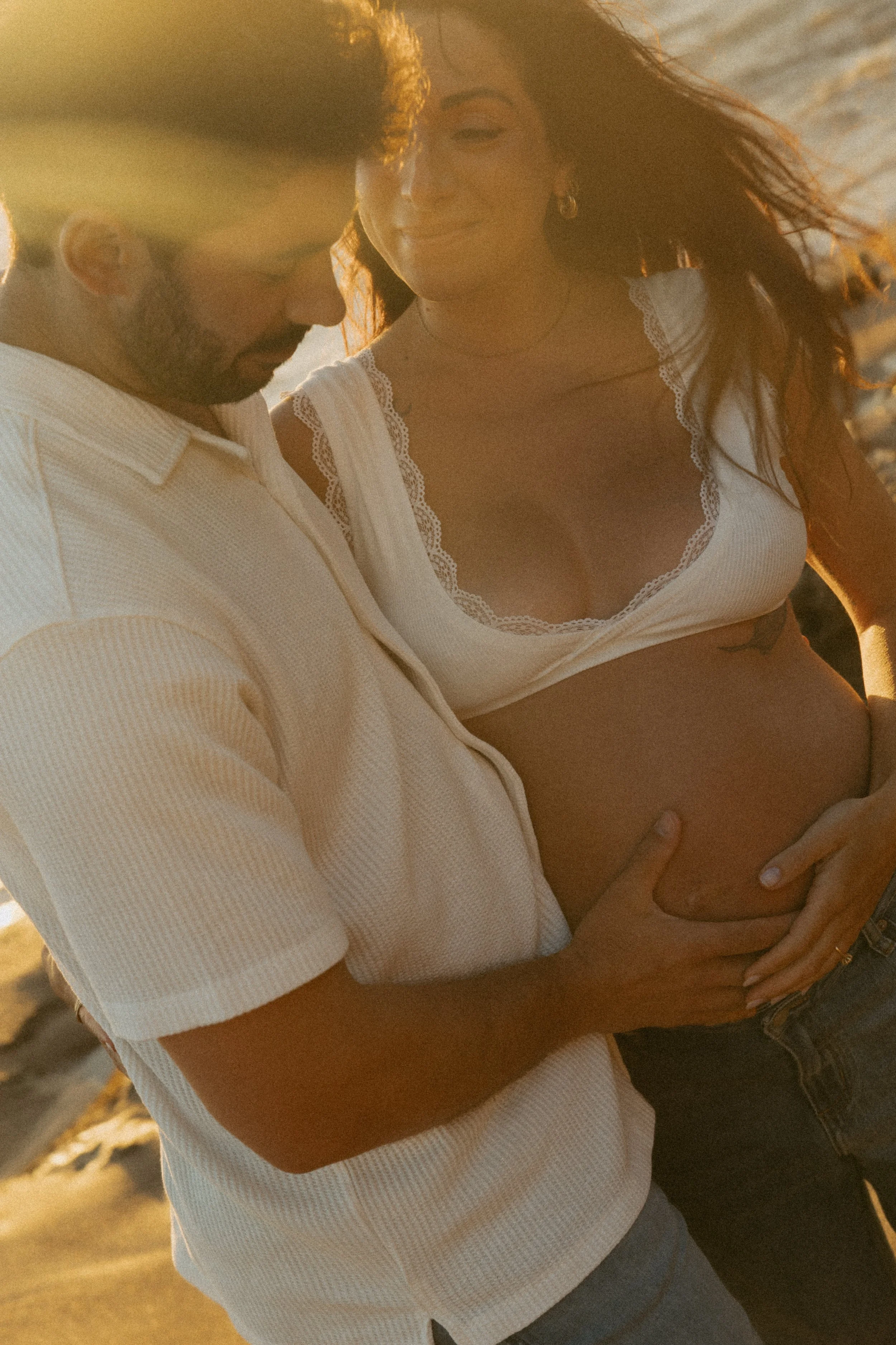 A couple standing close together outdoors at the beach during sunset, with the mans hand resting on the woman's pregnant belly.
Maternity, Newborn, Family & Couples Photography | Doreen, Melbourne