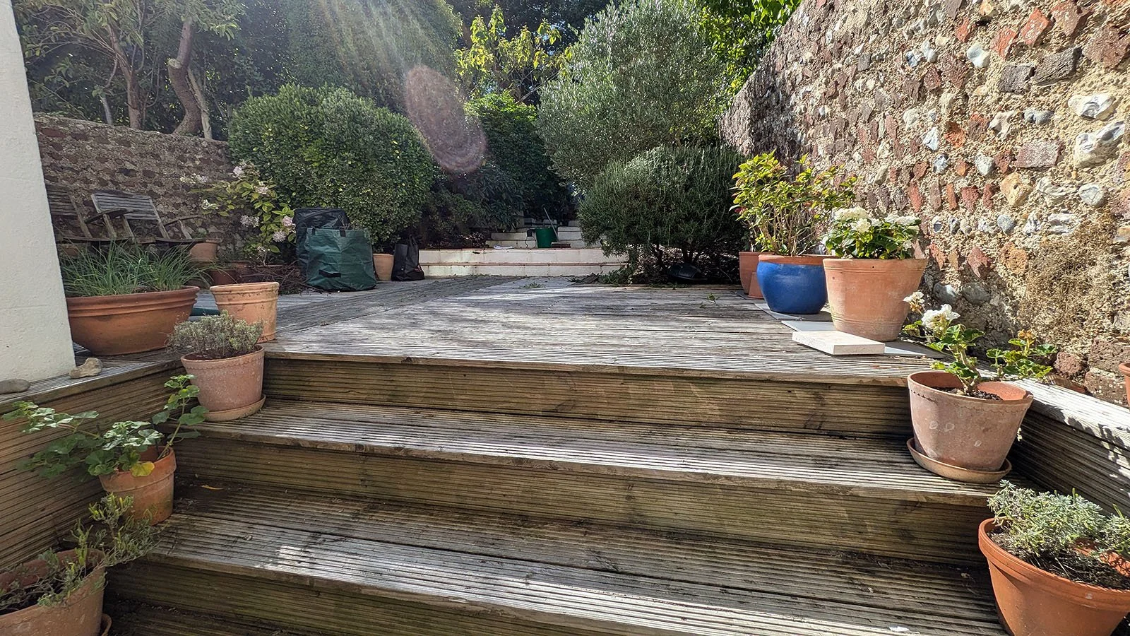 Old wooden decking overgrown garden