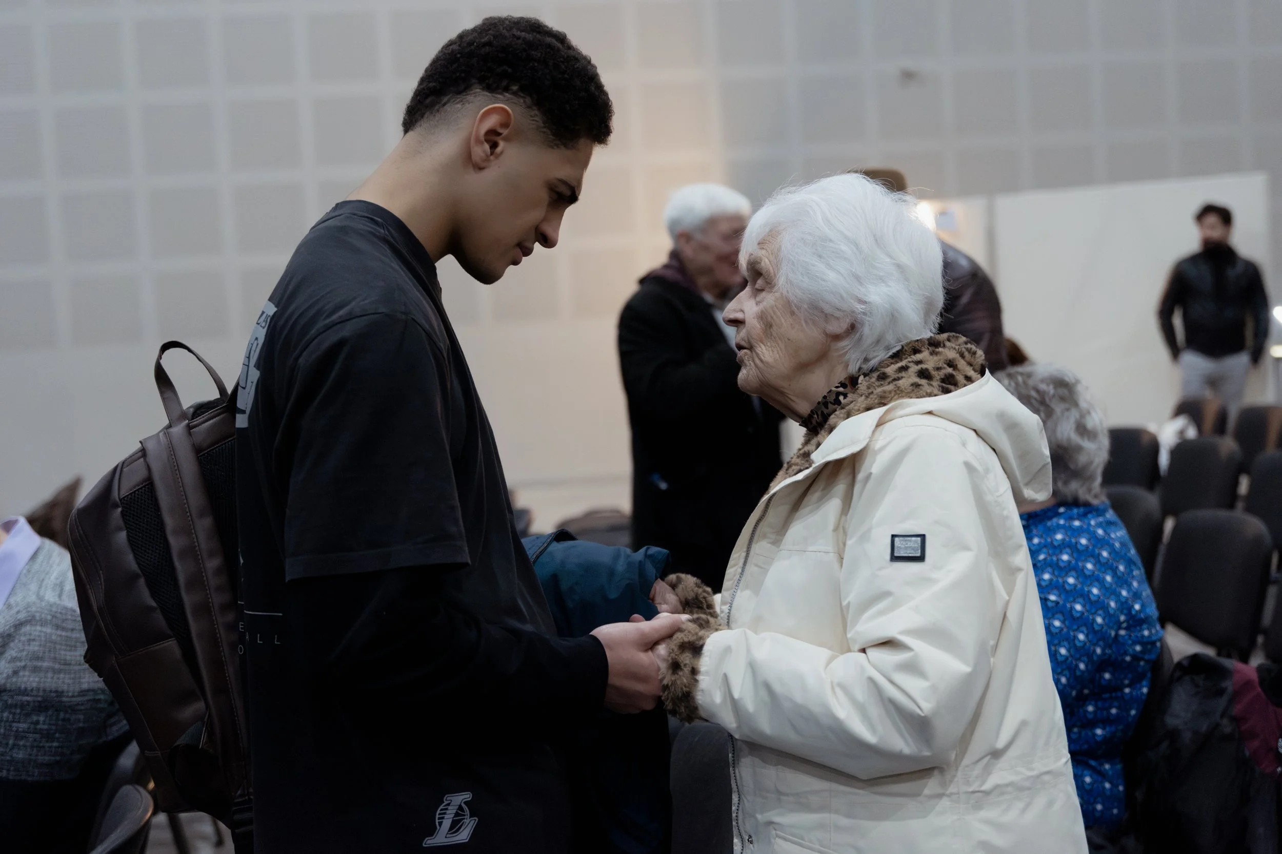 Older lady praying for young man
