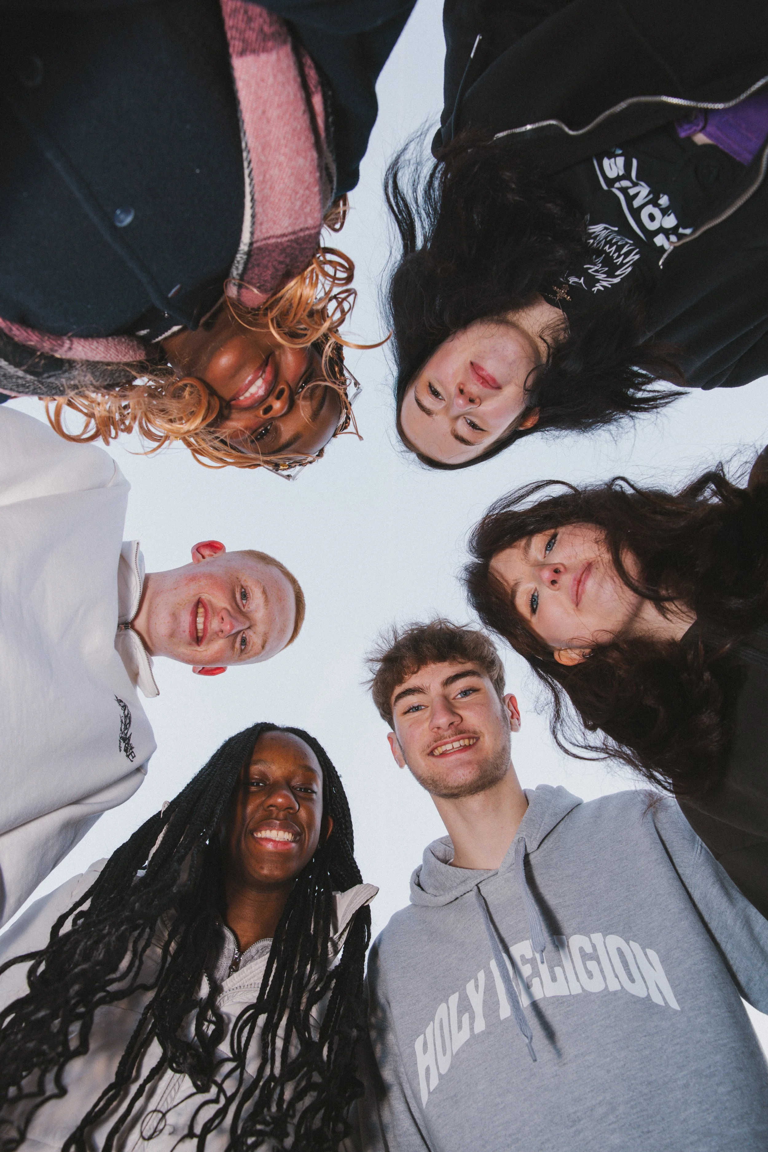 Smiling students looking down at camera